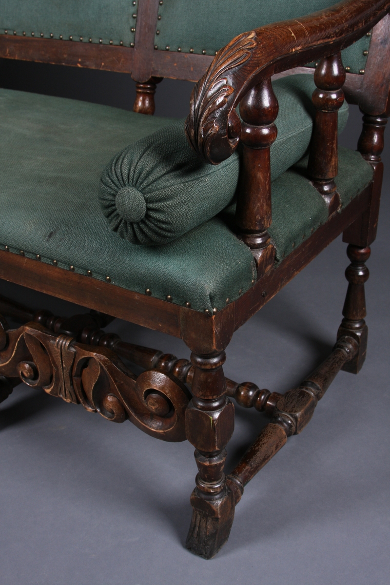 I utskjæringene over tre felter i sofaens rygg er det våpenskjold (byvåpen). Det venstre har en nøkkel, det i midten er Lübecks dobbeltørn, det høyre har en borg med tre tårn og en port. Over to av tårnene er det en stjerne, over tårnet i midten et kors. Rundt våpenskjoldene (byvåpnene) er det ranker og blad. I midtstykket mellom sofaens frontbein er det også ranker, og på armlene er det blad.