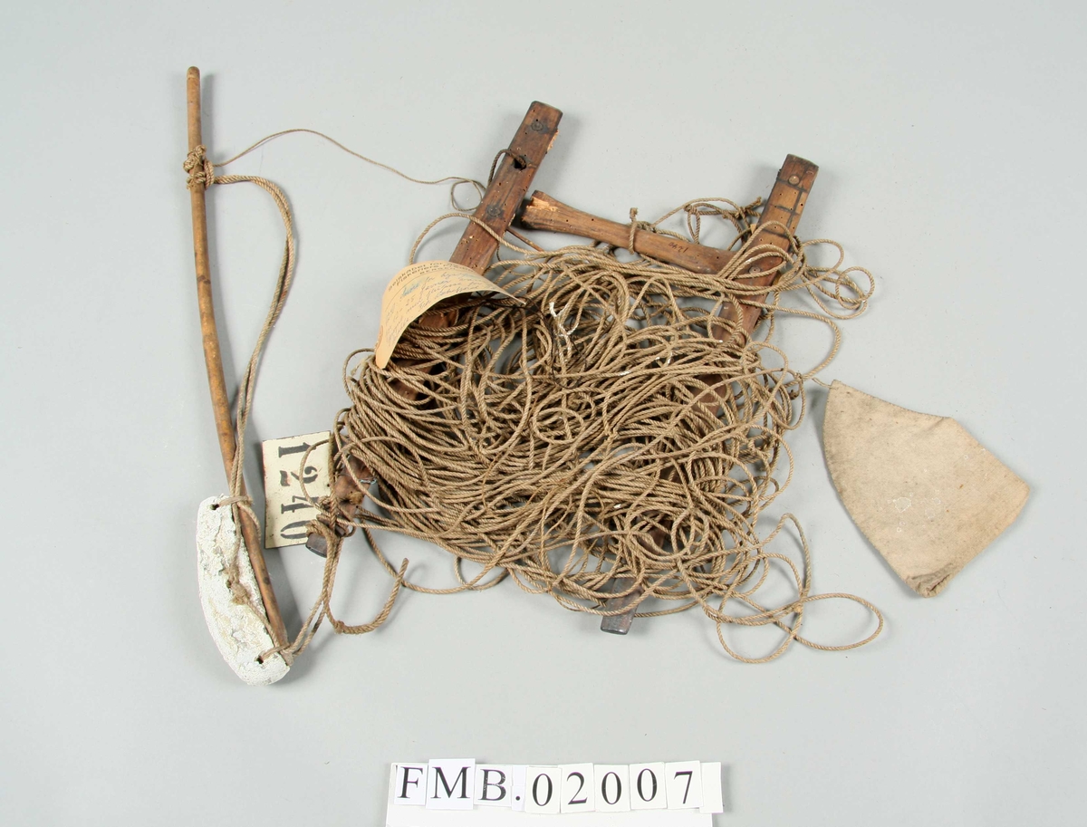 Snøre forsynt med agnpose og blylodd festet til en lang pinne. Agnposen er kremmerhusformet. Krok nr. 7. Klaven er ødelagt.