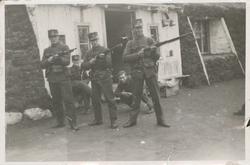 Fem soldater foran en gamme.