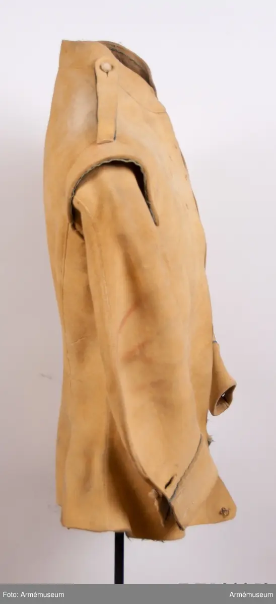 Kyller av gul älghud med blå linneband som kantning på insidan. Lätt utsvängt nertill med litet skört bak. Uppvik framtill, axelkarmar och låg krage.  Kragens linneband är i dag i upplösning och bara några trådar finns kvar.
Helt framtycke, och delat bakstycke samt två separata sidstycken. Sidsöm under ärmen.
Formade tvåsömsärmar med ärmuppslag. Ärmuppslagen har blå passpoal och sprund som knäpps med 3 koniska knappar klädda med sämskskinn i samma färg. Ett fjärde knapphål som är igensytt talar om att plagget blivit omsytt vid något tillfälle. En rad hål efter stygn på insidan av höger framstycke visar att plagget har haft en knappstolpe/underlott.
Axelklaffar fodrade med blått linne som knäpps vid kragen med samma knappar som ovan.
Plagget knäpps kant i kant mitt fram med 12 stycken hyskor och hakar av metall. Alla sömmar är sydda med oblekt lintråd.
Märkt inuti ryggen med "N 2".