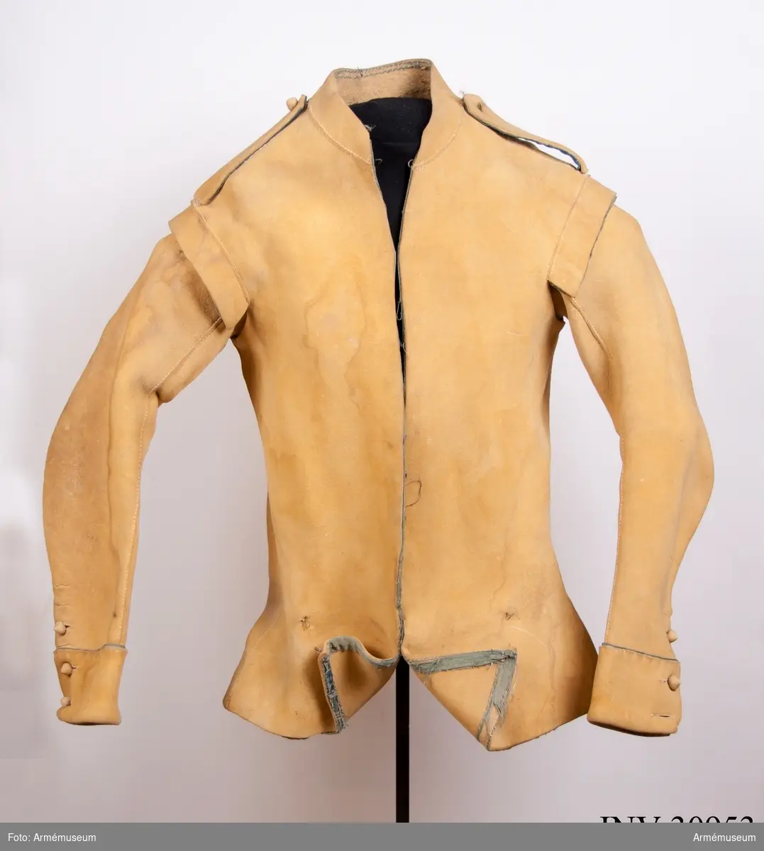 Kyller av gul älghud med smala blå linneband som kantning på insidan samt som passpoal vid övre kant av ärmuppslagen.
Helt framstycke med utsvängt kort skört med uppvik framtill, samt bakstycke med mitt-bak-söm och två sidstycken. Sidsöm under ärmen. Formad tvåsömsärm med ärmuppslag. Ärmuppslagen har sprund som knäpps med 3 koniska älghudsknappar i varje sida, även om det är utskuret 6 knapphål i höger ärm och 5 i den vänstra. De knapphål som inte används är ihopsydda. Liten axelkarm, samt axelklaffar på båda sidor som är fastsydda vid axelsömmen samt knäpps med älghudsknapp vid halsen. Knapp saknas på vänster axel.
Låg ståndkrage som har varit kantad på insidan med blått band. Detta saknas i dag.
Plagget knäpps kant i kant med 12 stycken hyskor och hakar mitt fram. Alla sömmar är sydda med oblekt lintråd.
Märkt inuti ryggen "No 1".
Kyllret skiljer sig något från samtida kyller av samma modell genom att de blå banden är smalare.