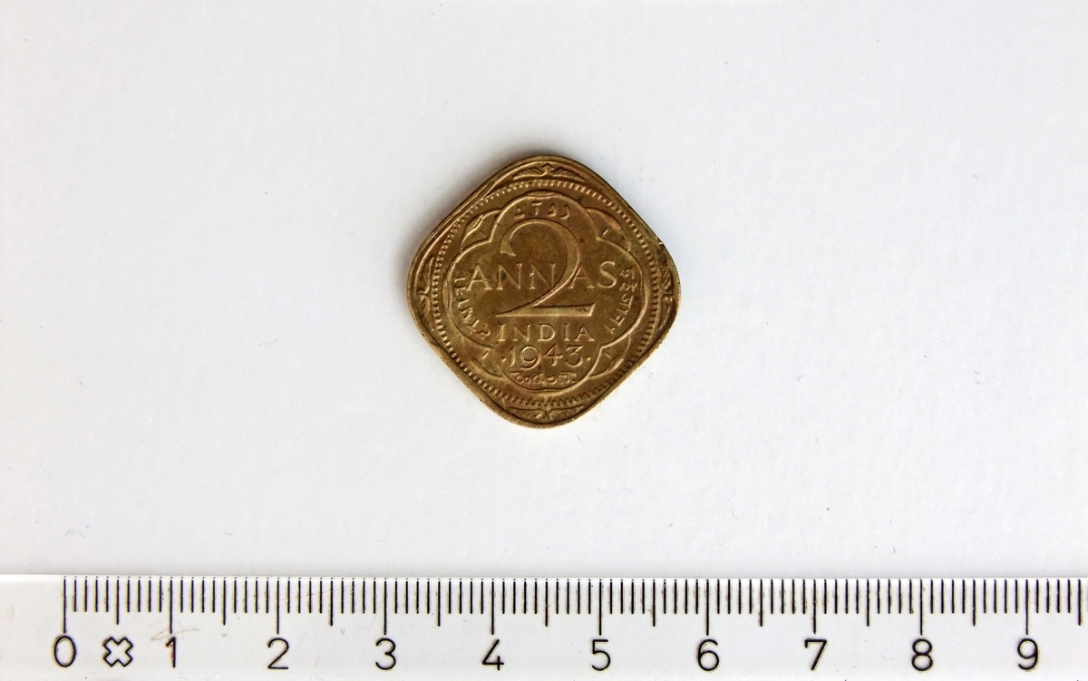 2 Annas,  INDIA,  1943,  George VI,  Nikkel-Messing.

2 Annas = 1/8 indisk rupi

Form:  Kvadratisk med runde hjørner.