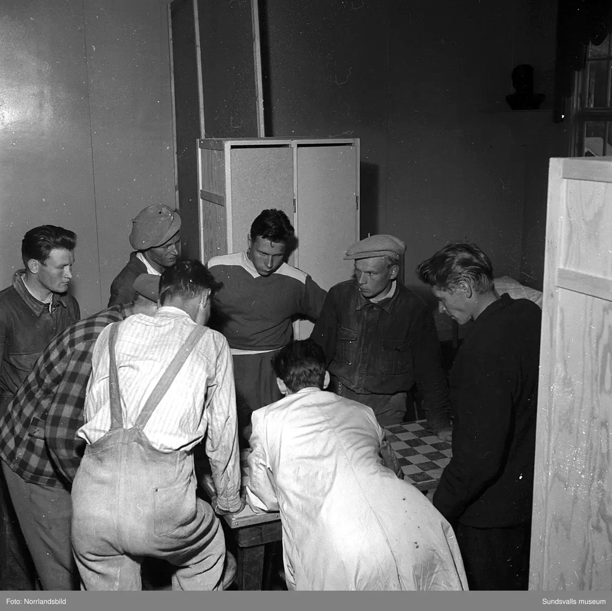 Sommaren 1951 anlände tolv finländska arbetare med båten Ragne till Sundsvall för att jobba vid Ortvikens sulfitfabrik. En välkommen förstärkning i tider då det var ont om arbetskraft. Som tillfällig förläggning användes Skönsbergs Folkets hus där den så kallade B-salen förvandlats till logement med tältsängar och i D-salen en trappa ned serverades maten. På den första bilden är det plåtslagaren Urhi Karlsson från Gamla Karleby som serveras spenatsoppa av Helga Rödén. På bild tre är det Eino Havu från Björneborg, till höger, som byter om efter sin första arbetsdag vid Ortviken.