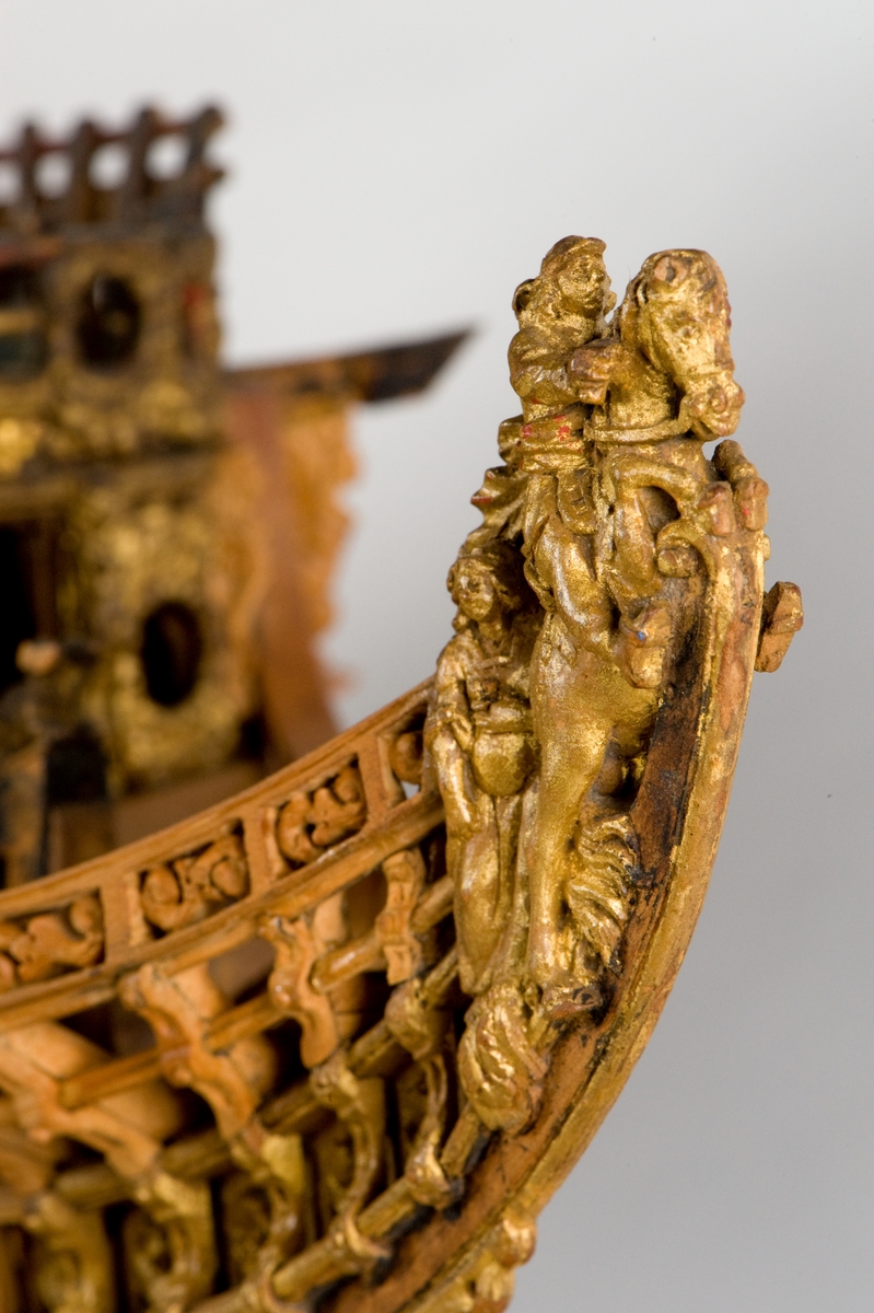 This unplanked model of a three-decker can be dated to c. 1660 and is one of the world's oldest models of a warship. Although not definitively identified, recent research links it to the Swedish ship *Riksäpplet*, designed by the English master shipwright Francis Sheldon and launched in 1661.     
The model was possibly made for Sheldon, who came to Sweden in 1659. He was one of a number of English shipwrights employed by the Swedish crown during the period. Previously, most Swedish warships had been built in the Dutch style.

From around 1660, the English Royal Navy’s administrators commissioned models that were accurately detailed and true to scale. These miniatures, which came to be called Navy or Admiralty Board models, had an unplanked lower hull to emphasise the shape of the underwater body. 

The model was restored by rear-admiral Jacob Hägg in the late 1890s. Missing parts have been reconstructed using lighter coloured wood.

3D model produced by Adam de Kaminski and Vasilis Haroupas for SMTM, 2023
