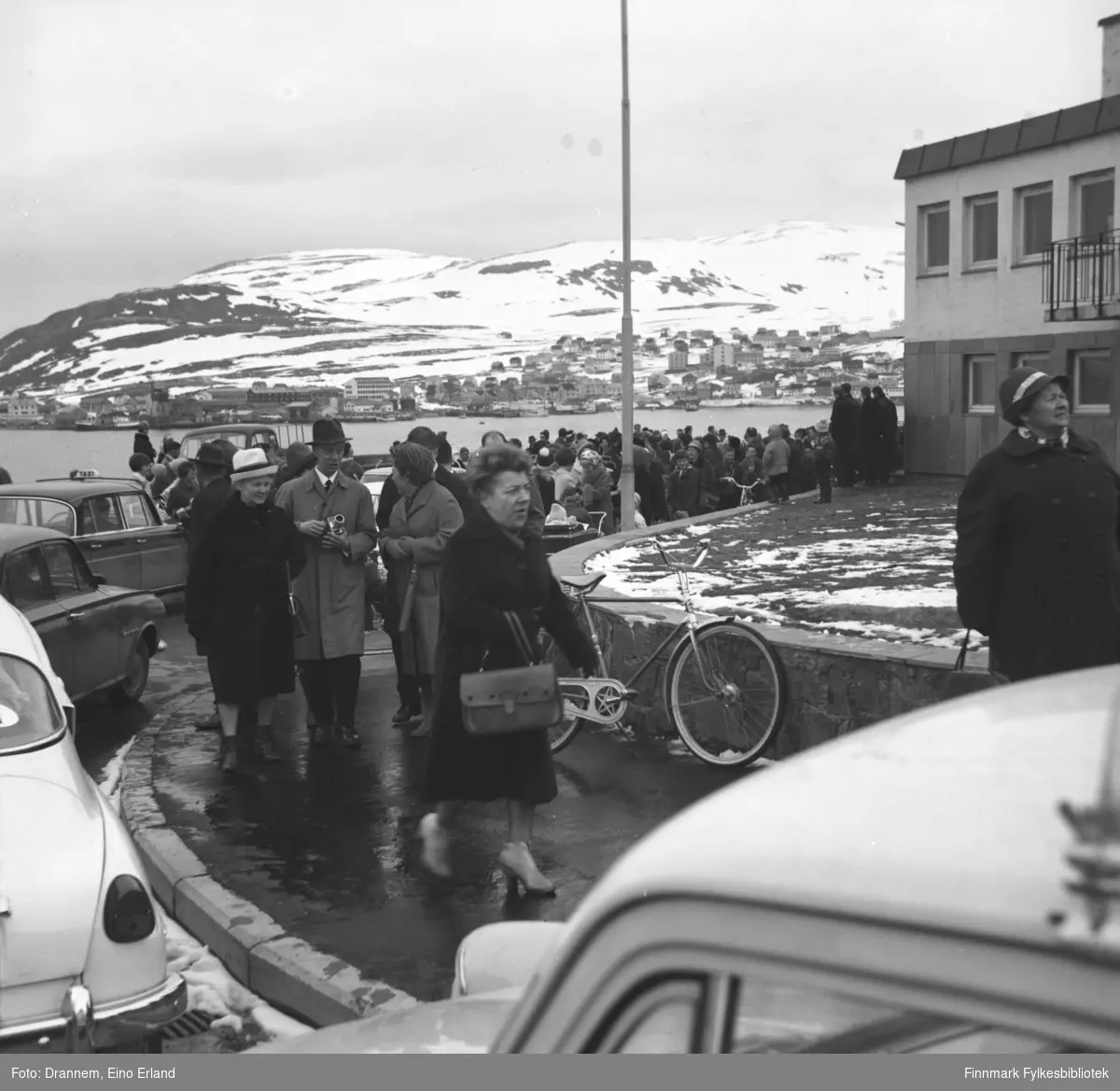 En del folk i krysset Sørøygata/Akkarfjordveien utenfor kirka. I bakgrunnen ses bydelen Fuglenes ved foten av Vard- og Storfjellet.