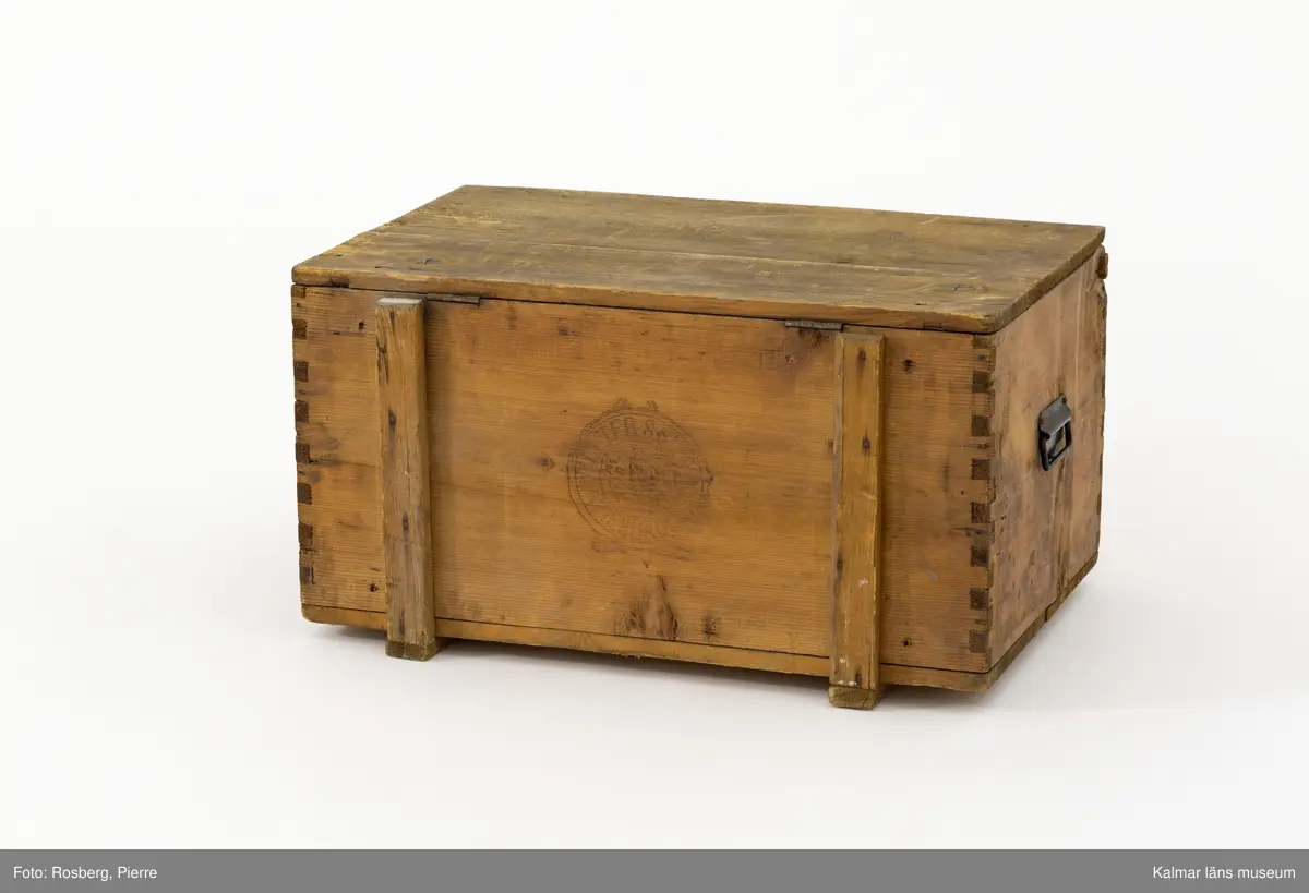 KLM 45273:74. Låda, av trä. Trälåda med lock. På gavlarna handtag av metall och på framsidan en bygel av metall där man kan stänga låda med ett hänglås.  På fram- och baksidan stämplad med ett emblem och texten Walter S Siegel Wiesbaden. På insidan är locket stämplat i svart med texten W.S.S. 5430 och två dekorerade remmare. På lockets insida sitter också två pappersetiketter klistrade. Den ena av vitt papper har text på tyska som berättar att lådan skickats från Wiesbaden till Stockholm. Den andra etiketten av rött papper har texten Transit-gods Trälleborg.