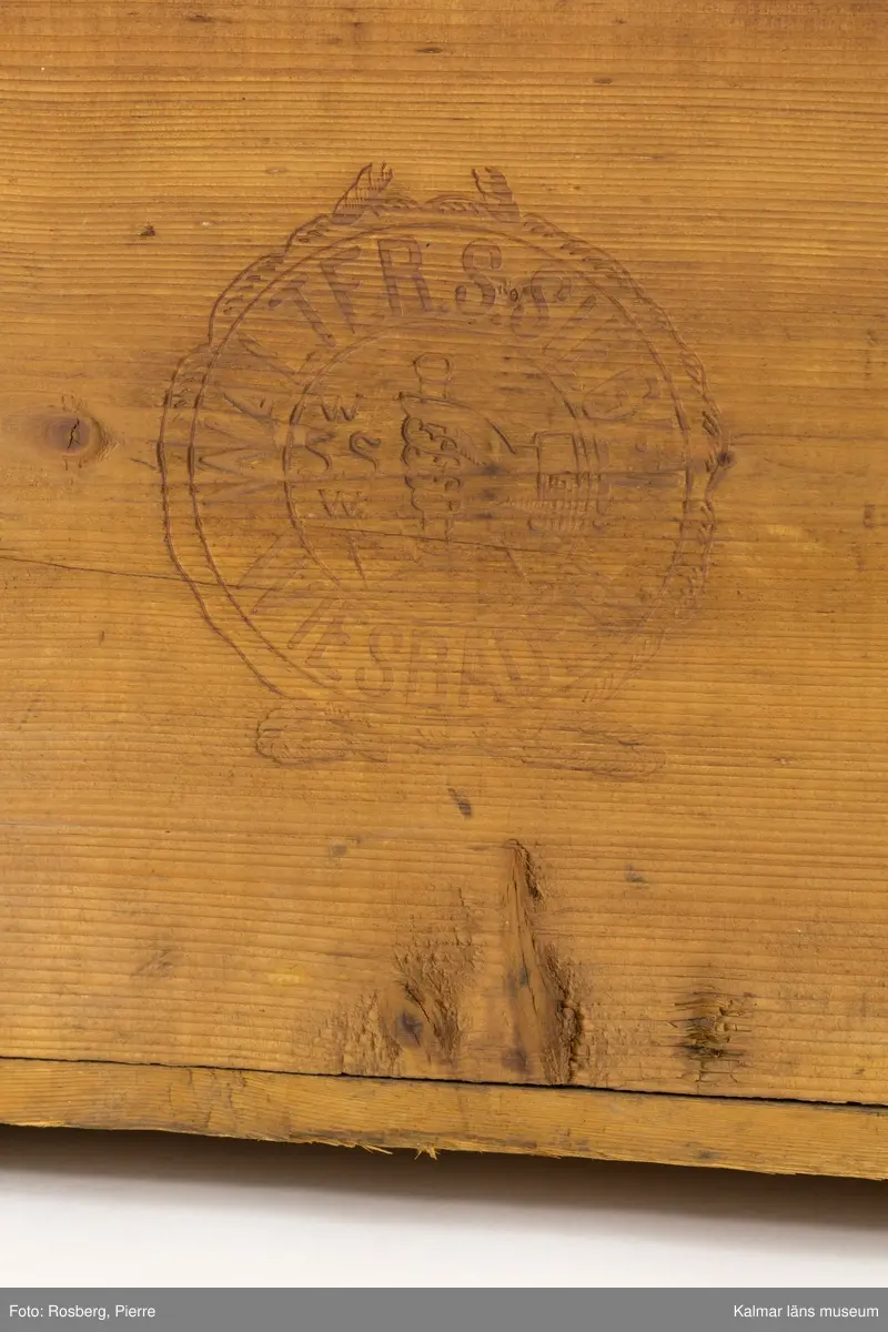 KLM 45273:74. Låda, av trä. Trälåda med lock. På gavlarna handtag av metall och på framsidan en bygel av metall där man kan stänga låda med ett hänglås.  På fram- och baksidan stämplad med ett emblem och texten Walter S Siegel Wiesbaden. På insidan är locket stämplat i svart med texten W.S.S. 5430 och två dekorerade remmare. På lockets insida sitter också två pappersetiketter klistrade. Den ena av vitt papper har text på tyska som berättar att lådan skickats från Wiesbaden till Stockholm. Den andra etiketten av rött papper har texten Transit-gods Trälleborg.