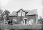 Familj utanför bostadshus, Raggarön, Börstils socken, Uppland