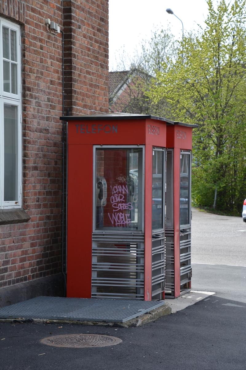 This is the story of how Norway’s most important conversation-space was designed by a young, freshly graduated man from Bergen.

“Norwegian architects are hereby invited…”
In the autumn of 1932, Oslo Telefonanlegginitiated an architectural competition. Finally, Oslo would get its own telephone booth. The city had had so called “talking-stations” from 1885, which in turn were overtaken by automatic telephones 
 only available at selected Narvesen kiosks. The state 
was of the opinion that now was the time to offer the public a better service; public telephone booths open 24/7, like the ones they already had in Sweden and England. But what would they look like, these new telephone booths? What considerations would it
 be necessary to take when designing it? The telegraph board developed a detailed list of demands and restraints: “The booth is intended to be placed outside on the streets and squares and need to be designed so that snow and ice does not hinder the opening and closing of the doors,” they wrote. “To prevent vandalism, theft, uncleanliness etc. inside the booth, it needs to be designed so that from all angles one may see what is going on in there.” Additionally, it would need to withstand storms and bad weather, and “preferably also being whipped by rain mixed with seawater” 

This was not all: The appearance would have to be «pleasing». The booth also needed to be movable, so that it could be taken in to be serviced at Telegrafverket’s main workshops. The reqired material was iron, and the surface was to be spray painted  preferably using car-body paint. There was a requirement for “a writing shelf, a pack shelf, and a suitable place for the telephone catalogue.” Also, there would need to be an illuminated TELEFON  sign, easily visible from all four angles. The total cost for each booth should not exceed 1000 kroner. The first prize for coming up with such a product was 800 kroner.

“Norwegianarchitects are hereby invited to partake in a competition for the design of a telephone booth…”  

The man with the solution
«At some point in 1932, Georg Fredrik sat at a party in Bergen. Maybe he felt a bit lost and forgotten as he often had throughout his life. He retreated to a quiet corner, took out a pencil and strted doodling on a matchbox.  According to my mother, this was how the telephone booth came into being.” In the book “Norges lille røde  historien om telefonkiosken,” Lars Fasting describes his father, the man who is far less known than the iconic architctural structure he left behind. Georg Fredrik Fasting was from Bergen, born into a family of working people and smallholders. One unusual facet of Georg Fredrik was that he was born without ears. His mother made sure he learnt to speak, read and write, 
ut Lars Fasting indicates that his father would seek refuge in drawing when the social challenges became too much to bear. And in the end drawing became his profession. In 1924 he secured a guarantor for a student loan, and started studying to become an a
rchitect at the NTH. Throughout the 1930s he entered several architectural competitions, with drafts produced, according to his son, “after work and in the late hours of the night.”

His efforts were not wasted. Out of 93 entries, with names such as “Flirt”, “Brrr”, “Ring” and “Amor”, the jury selected Fasting’s submission, “RIKS” as the new telephone booth: “The draft shows a strikingly simple solution to the task, technically as well as aesthetically well worked out.”

Taut and provident
Simple and aesthetc are the keywords here. Fasting had designed a booth pointing towards the future, and to modernism. Just how modern it was can be seen by comparing RIKS to the British telephone booth, also designed in the interwar-era. While the British version with it classicistic style is looking back to the heyday of the empire, Fasting’s booth is progressive and functionalistic. Like most Norwegian architects, Fasting broke with the classicistic style of architecture after the Stockholm-exhibition in 1930. “After it, almost all buildings erected in Norway until the German invasion in 1940, were in the functionalistic architectural style,” writes senior curator of architecture at the Norwegian National Museum, Ulf Grønvold, in the book, “Den lille røde”.“TheNorwegian booth is a piece of functionalistic architecture, an asymmetric composition with its roof slab overhanging the word TELEFON, in bold sans seraph lettering,”concludes Ulf Grønvold.

Fashionably red
And it was red. Fasting chose a colour which was part of the modern palette. “A bright red colour, but not as shiny as a signal red, the character of the colour places it among the fashionable colours within functionalism,” states paintings conservator and researcher in NIKU (Norwegian Institute for Cultural Heitage Research), Jon Brænne. In his opinion, Fasting went for visibility without making the booth stand out too much from its surroundings. The original colour was in use up to around 1950, when it changed to signal red. Towards the end of the 1970s the clour was again adjusted towards today’s orangey red.

The design, however, has not changed. RIKS is eighty years and still looks remarkably good. That’s what makes Fasting’s telephone booth a classic  even before it was added to DOCOMOMO’s list over moden icons of design. For Telenor, the telephone booth has served as a pathway into the hearts of the public. For many, Telenor (Televerket) was synonymous with exactly this telephone booth, because this was where one would go to place a call. Having a home
phone was not common until the 1980s. As such the red box became part of the Norwegian everyday and consciousness. The symbol- and publicity value of this is hard to evaluate, but in 2007 it was time to give honour where honour was due, Telenor, in consul
tation with the Directorate for Cultural Heritage, decided to preserve 100 telephone booths for all eternity.

And what about Georg Fredrik Fasting? What happened to him? At the age of 56 an entry in his diary states: «I CAN HEAR». As the first person in th world he had undergone an operation where he had ear canals constructed and eardrums fitted. For the rest of his life, the man behind Norway’s own telephone booth could answer the telephone himself.

Source: Norges lille røde historien om telefonkiosken (2007), issued by The Norwegian Telecom Museum and Telenor Cultural Heritage.