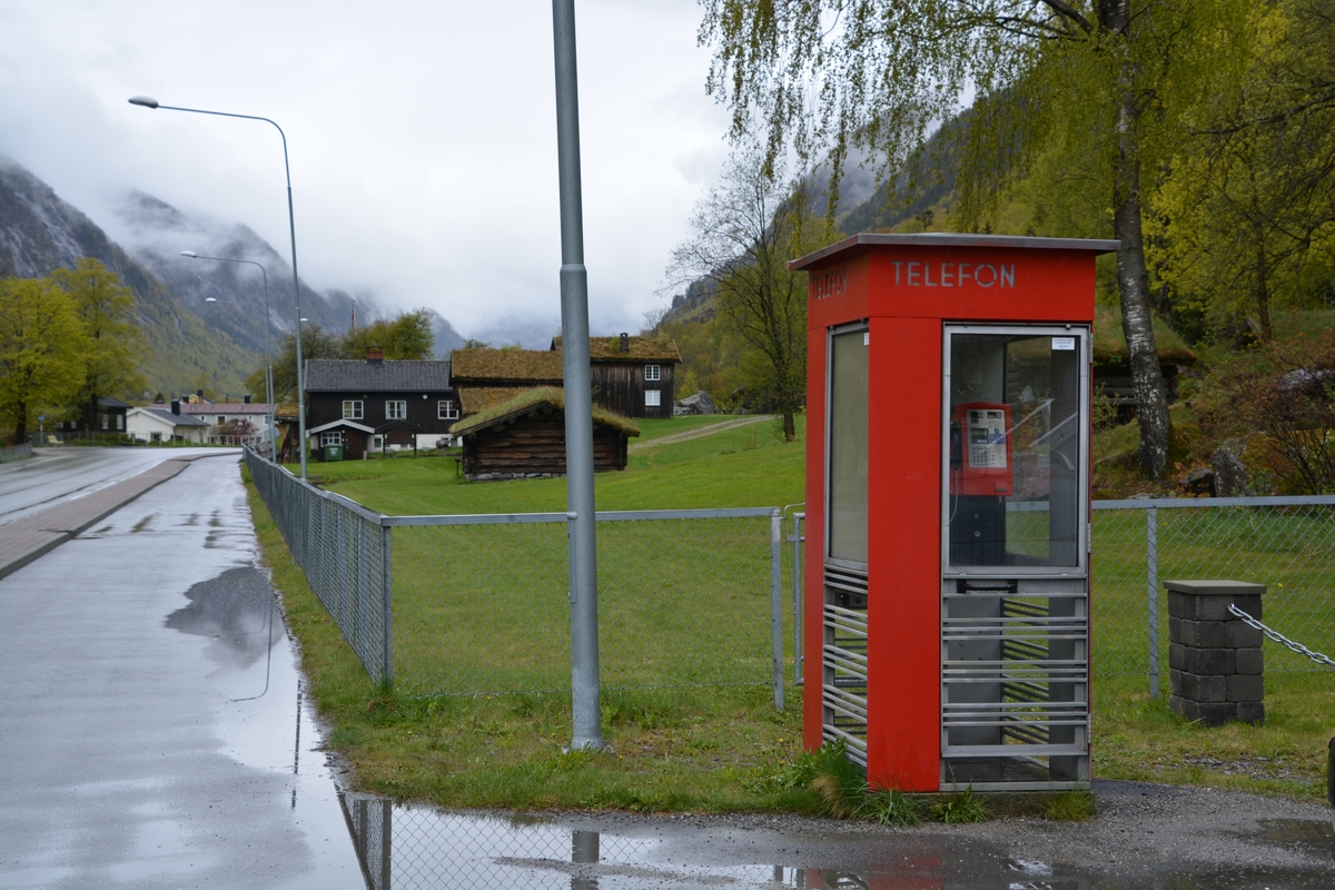 This is the story of how Norway’s most important conversation-space was designed by a young, freshly graduated man from Bergen.

“Norwegian architects are hereby invited…”
In the autumn of 1932, Oslo Telefonanlegginitiated an architectural competition. Finally, Oslo would get its own telephone booth. The city had had so called “talking-stations” from 1885, which in turn were overtaken by automatic telephones 
 only available at selected Narvesen kiosks. The state 
was of the opinion that now was the time to offer the public a better service; public telephone booths open 24/7, like the ones they already had in Sweden and England. But what would they look like, these new telephone booths? What considerations would it
 be necessary to take when designing it? The telegraph board developed a detailed list of demands and restraints: “The booth is intended to be placed outside on the streets and squares and need to be designed so that snow and ice does not hinder the opening and closing of the doors,” they wrote. “To prevent vandalism, theft, uncleanliness etc. inside the booth, it needs to be designed so that from all angles one may see what is going on in there.” Additionally, it would need to withstand storms and bad weather, and “preferably also being whipped by rain mixed with seawater” 

This was not all: The appearance would have to be «pleasing». The booth also needed to be movable, so that it could be taken in to be serviced at Telegrafverket’s main workshops. The reqired material was iron, and the surface was to be spray painted  preferably using car-body paint. There was a requirement for “a writing shelf, a pack shelf, and a suitable place for the telephone catalogue.” Also, there would need to be an illuminated TELEFON  sign, easily visible from all four angles. The total cost for each booth should not exceed 1000 kroner. The first prize for coming up with such a product was 800 kroner.

“Norwegianarchitects are hereby invited to partake in a competition for the design of a telephone booth…”  

The man with the solution
«At some point in 1932, Georg Fredrik sat at a party in Bergen. Maybe he felt a bit lost and forgotten as he often had throughout his life. He retreated to a quiet corner, took out a pencil and strted doodling on a matchbox.  According to my mother, this was how the telephone booth came into being.” In the book “Norges lille røde  historien om telefonkiosken,” Lars Fasting describes his father, the man who is far less known than the iconic architctural structure he left behind. Georg Fredrik Fasting was from Bergen, born into a family of working people and smallholders. One unusual facet of Georg Fredrik was that he was born without ears. His mother made sure he learnt to speak, read and write, 
ut Lars Fasting indicates that his father would seek refuge in drawing when the social challenges became too much to bear. And in the end drawing became his profession. In 1924 he secured a guarantor for a student loan, and started studying to become an a
rchitect at the NTH. Throughout the 1930s he entered several architectural competitions, with drafts produced, according to his son, “after work and in the late hours of the night.”

His efforts were not wasted. Out of 93 entries, with names such as “Flirt”, “Brrr”, “Ring” and “Amor”, the jury selected Fasting’s submission, “RIKS” as the new telephone booth: “The draft shows a strikingly simple solution to the task, technically as well as aesthetically well worked out.”

Taut and provident
Simple and aesthetc are the keywords here. Fasting had designed a booth pointing towards the future, and to modernism. Just how modern it was can be seen by comparing RIKS to the British telephone booth, also designed in the interwar-era. While the British version with it classicistic style is looking back to the heyday of the empire, Fasting’s booth is progressive and functionalistic. Like most Norwegian architects, Fasting broke with the classicistic style of architecture after the Stockholm-exhibition in 1930. “After it, almost all buildings erected in Norway until the German invasion in 1940, were in the functionalistic architectural style,” writes senior curator of architecture at the Norwegian National Museum, Ulf Grønvold, in the book, “Den lille røde”.“TheNorwegian booth is a piece of functionalistic architecture, an asymmetric composition with its roof slab overhanging the word TELEFON, in bold sans seraph lettering,”concludes Ulf Grønvold.

Fashionably red
And it was red. Fasting chose a colour which was part of the modern palette. “A bright red colour, but not as shiny as a signal red, the character of the colour places it among the fashionable colours within functionalism,” states paintings conservator and researcher in NIKU (Norwegian Institute for Cultural Heitage Research), Jon Brænne. In his opinion, Fasting went for visibility without making the booth stand out too much from its surroundings. The original colour was in use up to around 1950, when it changed to signal red. Towards the end of the 1970s the clour was again adjusted towards today’s orangey red.

The design, however, has not changed. RIKS is eighty years and still looks remarkably good. That’s what makes Fasting’s telephone booth a classic  even before it was added to DOCOMOMO’s list over moden icons of design. For Telenor, the telephone booth has served as a pathway into the hearts of the public. For many, Telenor (Televerket) was synonymous with exactly this telephone booth, because this was where one would go to place a call. Having a home
phone was not common until the 1980s. As such the red box became part of the Norwegian everyday and consciousness. The symbol- and publicity value of this is hard to evaluate, but in 2007 it was time to give honour where honour was due, Telenor, in consul
tation with the Directorate for Cultural Heritage, decided to preserve 100 telephone booths for all eternity.

And what about Georg Fredrik Fasting? What happened to him? At the age of 56 an entry in his diary states: «I CAN HEAR». As the first person in th world he had undergone an operation where he had ear canals constructed and eardrums fitted. For the rest of his life, the man behind Norway’s own telephone booth could answer the telephone himself.

Source: Norges lille røde historien om telefonkiosken (2007), issued by The Norwegian Telecom Museum and Telenor Cultural Heritage.