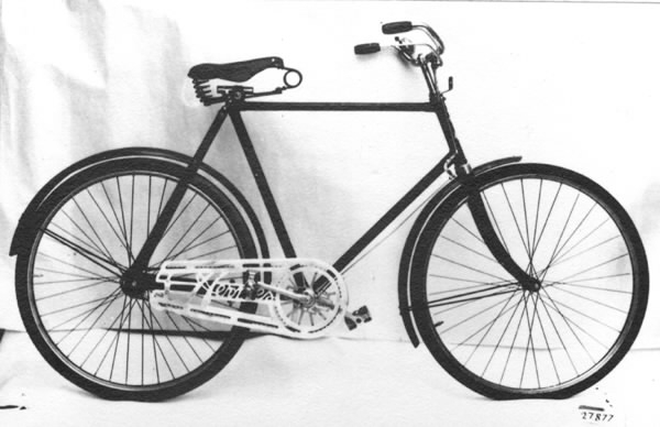 Cykel av stålrör. Diamond-ram. Spiralfjädrad lädersadel med pressat märke, text: "MANUFACTURED IN BIRMINHAM" (se bild). Styrhandtag av mönstrad celluloid. Ringklocka. På styret handtag till bakre fälgbroms. Lykthållare. Stänkskärmar av plåt. Stålfälgar, förnicklade med svart mittrand, kantad av röda linjer. Suspensionsekrar, svartmålade. Sammansatt vev. Frihjulsnav utan broms. Kedjeskydd av lättmetall, genombrutet med mönster: "Hermes". Styre, bromsinrättning, gaffelkrona och vevparti förkromade. I övrigt svart med rektanglar av röda linjer på skärmar och gaffelsidor. På styrrörets framsida en springande, fackelbärande mansgestal, runt vilken läses HERMES. Där ovan stiliserande örnvingar krönta av riksäpple. Nedanför sköld med text: "A.B. NYMANS VERKSTÄDER, UPSALA".