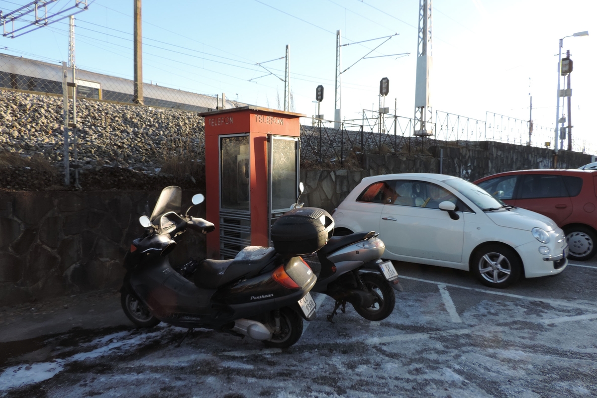 This is the story of how Norway’s most important conversation-space was designed by a young, freshly graduated man from Bergen.

“Norwegian architects are hereby invited…”
In the autumn of 1932, Oslo Telefonanlegginitiated an architectural competition. Finally, Oslo would get its own telephone booth. The city had had so called “talking-stations” from 1885, which in turn were overtaken by automatic telephones 
 only available at selected Narvesen kiosks. The state 
was of the opinion that now was the time to offer the public a better service; public telephone booths open 24/7, like the ones they already had in Sweden and England. But what would they look like, these new telephone booths? What considerations would it
 be necessary to take when designing it? The telegraph board developed a detailed list of demands and restraints: “The booth is intended to be placed outside on the streets and squares and need to be designed so that snow and ice does not hinder the opening and closing of the doors,” they wrote. “To prevent vandalism, theft, uncleanliness etc. inside the booth, it needs to be designed so that from all angles one may see what is going on in there.” Additionally, it would need to withstand storms and bad weather, and “preferably also being whipped by rain mixed with seawater” 

This was not all: The appearance would have to be «pleasing». The booth also needed to be movable, so that it could be taken in to be serviced at Telegrafverket’s main workshops. The reqired material was iron, and the surface was to be spray painted  preferably using car-body paint. There was a requirement for “a writing shelf, a pack shelf, and a suitable place for the telephone catalogue.” Also, there would need to be an illuminated TELEFON  sign, easily visible from all four angles. The total cost for each booth should not exceed 1000 kroner. The first prize for coming up with such a product was 800 kroner.

“Norwegianarchitects are hereby invited to partake in a competition for the design of a telephone booth…”  

The man with the solution
«At some point in 1932, Georg Fredrik sat at a party in Bergen. Maybe he felt a bit lost and forgotten as he often had throughout his life. He retreated to a quiet corner, took out a pencil and strted doodling on a matchbox.  According to my mother, this was how the telephone booth came into being.” In the book “Norges lille røde  historien om telefonkiosken,” Lars Fasting describes his father, the man who is far less known than the iconic architctural structure he left behind. Georg Fredrik Fasting was from Bergen, born into a family of working people and smallholders. One unusual facet of Georg Fredrik was that he was born without ears. His mother made sure he learnt to speak, read and write, 
ut Lars Fasting indicates that his father would seek refuge in drawing when the social challenges became too much to bear. And in the end drawing became his profession. In 1924 he secured a guarantor for a student loan, and started studying to become an a
rchitect at the NTH. Throughout the 1930s he entered several architectural competitions, with drafts produced, according to his son, “after work and in the late hours of the night.”

His efforts were not wasted. Out of 93 entries, with names such as “Flirt”, “Brrr”, “Ring” and “Amor”, the jury selected Fasting’s submission, “RIKS” as the new telephone booth: “The draft shows a strikingly simple solution to the task, technically as well as aesthetically well worked out.”

Taut and provident
Simple and aesthetc are the keywords here. Fasting had designed a booth pointing towards the future, and to modernism. Just how modern it was can be seen by comparing RIKS to the British telephone booth, also designed in the interwar-era. While the British version with it classicistic style is looking back to the heyday of the empire, Fasting’s booth is progressive and functionalistic. Like most Norwegian architects, Fasting broke with the classicistic style of architecture after the Stockholm-exhibition in 1930. “After it, almost all buildings erected in Norway until the German invasion in 1940, were in the functionalistic architectural style,” writes senior curator of architecture at the Norwegian National Museum, Ulf Grønvold, in the book, “Den lille røde”.“TheNorwegian booth is a piece of functionalistic architecture, an asymmetric composition with its roof slab overhanging the word TELEFON, in bold sans seraph lettering,”concludes Ulf Grønvold.

Fashionably red
And it was red. Fasting chose a colour which was part of the modern palette. “A bright red colour, but not as shiny as a signal red, the character of the colour places it among the fashionable colours within functionalism,” states paintings conservator and researcher in NIKU (Norwegian Institute for Cultural Heitage Research), Jon Brænne. In his opinion, Fasting went for visibility without making the booth stand out too much from its surroundings. The original colour was in use up to around 1950, when it changed to signal red. Towards the end of the 1970s the clour was again adjusted towards today’s orangey red.

The design, however, has not changed. RIKS is eighty years and still looks remarkably good. That’s what makes Fasting’s telephone booth a classic  even before it was added to DOCOMOMO’s list over moden icons of design. For Telenor, the telephone booth has served as a pathway into the hearts of the public. For many, Telenor (Televerket) was synonymous with exactly this telephone booth, because this was where one would go to place a call. Having a home
phone was not common until the 1980s. As such the red box became part of the Norwegian everyday and consciousness. The symbol- and publicity value of this is hard to evaluate, but in 2007 it was time to give honour where honour was due, Telenor, in consul
tation with the Directorate for Cultural Heritage, decided to preserve 100 telephone booths for all eternity.

And what about Georg Fredrik Fasting? What happened to him? At the age of 56 an entry in his diary states: «I CAN HEAR». As the first person in th world he had undergone an operation where he had ear canals constructed and eardrums fitted. For the rest of his life, the man behind Norway’s own telephone booth could answer the telephone himself.

Source: Norges lille røde historien om telefonkiosken (2007), issued by The Norwegian Telecom Museum and Telenor Cultural Heritage.