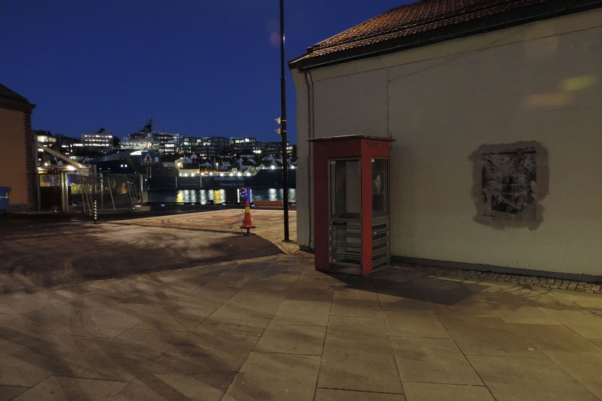 This is the story of how Norway’s most important conversation-space was designed by a young, freshly graduated man from Bergen.

“Norwegian architects are hereby invited…”
In the autumn of 1932, Oslo Telefonanlegginitiated an architectural competition. Finally, Oslo would get its own telephone booth. The city had had so called “talking-stations” from 1885, which in turn were overtaken by automatic telephones 
 only available at selected Narvesen kiosks. The state 
was of the opinion that now was the time to offer the public a better service; public telephone booths open 24/7, like the ones they already had in Sweden and England. But what would they look like, these new telephone booths? What considerations would it
 be necessary to take when designing it? The telegraph board developed a detailed list of demands and restraints: “The booth is intended to be placed outside on the streets and squares and need to be designed so that snow and ice does not hinder the opening and closing of the doors,” they wrote. “To prevent vandalism, theft, uncleanliness etc. inside the booth, it needs to be designed so that from all angles one may see what is going on in there.” Additionally, it would need to withstand storms and bad weather, and “preferably also being whipped by rain mixed with seawater” 

This was not all: The appearance would have to be «pleasing». The booth also needed to be movable, so that it could be taken in to be serviced at Telegrafverket’s main workshops. The reqired material was iron, and the surface was to be spray painted  preferably using car-body paint. There was a requirement for “a writing shelf, a pack shelf, and a suitable place for the telephone catalogue.” Also, there would need to be an illuminated TELEFON  sign, easily visible from all four angles. The total cost for each booth should not exceed 1000 kroner. The first prize for coming up with such a product was 800 kroner.

“Norwegianarchitects are hereby invited to partake in a competition for the design of a telephone booth…”  

The man with the solution
«At some point in 1932, Georg Fredrik sat at a party in Bergen. Maybe he felt a bit lost and forgotten as he often had throughout his life. He retreated to a quiet corner, took out a pencil and strted doodling on a matchbox.  According to my mother, this was how the telephone booth came into being.” In the book “Norges lille røde  historien om telefonkiosken,” Lars Fasting describes his father, the man who is far less known than the iconic architctural structure he left behind. Georg Fredrik Fasting was from Bergen, born into a family of working people and smallholders. One unusual facet of Georg Fredrik was that he was born without ears. His mother made sure he learnt to speak, read and write, 
ut Lars Fasting indicates that his father would seek refuge in drawing when the social challenges became too much to bear. And in the end drawing became his profession. In 1924 he secured a guarantor for a student loan, and started studying to become an a
rchitect at the NTH. Throughout the 1930s he entered several architectural competitions, with drafts produced, according to his son, “after work and in the late hours of the night.”

His efforts were not wasted. Out of 93 entries, with names such as “Flirt”, “Brrr”, “Ring” and “Amor”, the jury selected Fasting’s submission, “RIKS” as the new telephone booth: “The draft shows a strikingly simple solution to the task, technically as well as aesthetically well worked out.”

Taut and provident
Simple and aesthetc are the keywords here. Fasting had designed a booth pointing towards the future, and to modernism. Just how modern it was can be seen by comparing RIKS to the British telephone booth, also designed in the interwar-era. While the British version with it classicistic style is looking back to the heyday of the empire, Fasting’s booth is progressive and functionalistic. Like most Norwegian architects, Fasting broke with the classicistic style of architecture after the Stockholm-exhibition in 1930. “After it, almost all buildings erected in Norway until the German invasion in 1940, were in the functionalistic architectural style,” writes senior curator of architecture at the Norwegian National Museum, Ulf Grønvold, in the book, “Den lille røde”.“TheNorwegian booth is a piece of functionalistic architecture, an asymmetric composition with its roof slab overhanging the word TELEFON, in bold sans seraph lettering,”concludes Ulf Grønvold.

Fashionably red
And it was red. Fasting chose a colour which was part of the modern palette. “A bright red colour, but not as shiny as a signal red, the character of the colour places it among the fashionable colours within functionalism,” states paintings conservator and researcher in NIKU (Norwegian Institute for Cultural Heitage Research), Jon Brænne. In his opinion, Fasting went for visibility without making the booth stand out too much from its surroundings. The original colour was in use up to around 1950, when it changed to signal red. Towards the end of the 1970s the clour was again adjusted towards today’s orangey red.

The design, however, has not changed. RIKS is eighty years and still looks remarkably good. That’s what makes Fasting’s telephone booth a classic  even before it was added to DOCOMOMO’s list over moden icons of design. For Telenor, the telephone booth has served as a pathway into the hearts of the public. For many, Telenor (Televerket) was synonymous with exactly this telephone booth, because this was where one would go to place a call. Having a home
phone was not common until the 1980s. As such the red box became part of the Norwegian everyday and consciousness. The symbol- and publicity value of this is hard to evaluate, but in 2007 it was time to give honour where honour was due, Telenor, in consul
tation with the Directorate for Cultural Heritage, decided to preserve 100 telephone booths for all eternity.

And what about Georg Fredrik Fasting? What happened to him? At the age of 56 an entry in his diary states: «I CAN HEAR». As the first person in th world he had undergone an operation where he had ear canals constructed and eardrums fitted. For the rest of his life, the man behind Norway’s own telephone booth could answer the telephone himself.

Source: Norges lille røde historien om telefonkiosken (2007), issued by The Norwegian Telecom Museum and Telenor Cultural Heritage.