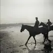 Värnpliktiga rider på stranden. Norrlands dragonregemente K4, Umeå, 1955-1956.