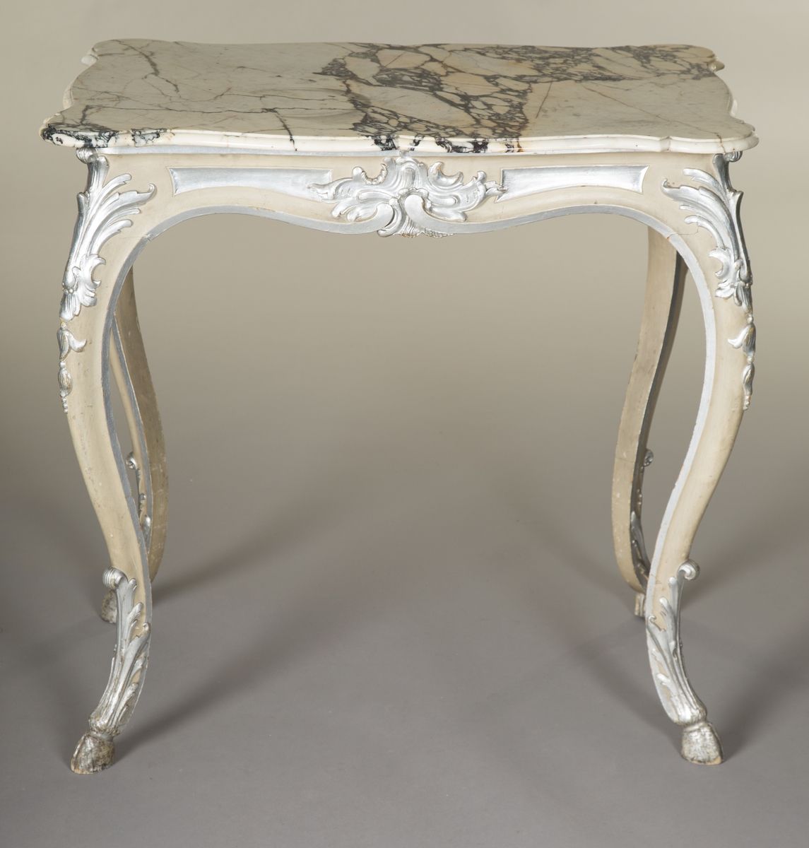 Rektangulært bord med treunderstell og marmorplate i nyrokokko. Malt lysegrått med forsølvete ornamenter. Sort og hvit marmorplate med svunget kontur. Cabrioleben med kloveavslutning. Sargens midtfelter har på kortsidene utskåret rocaille, og på langsidene skåret rankeverk. Bena har også skåret rankeverk.