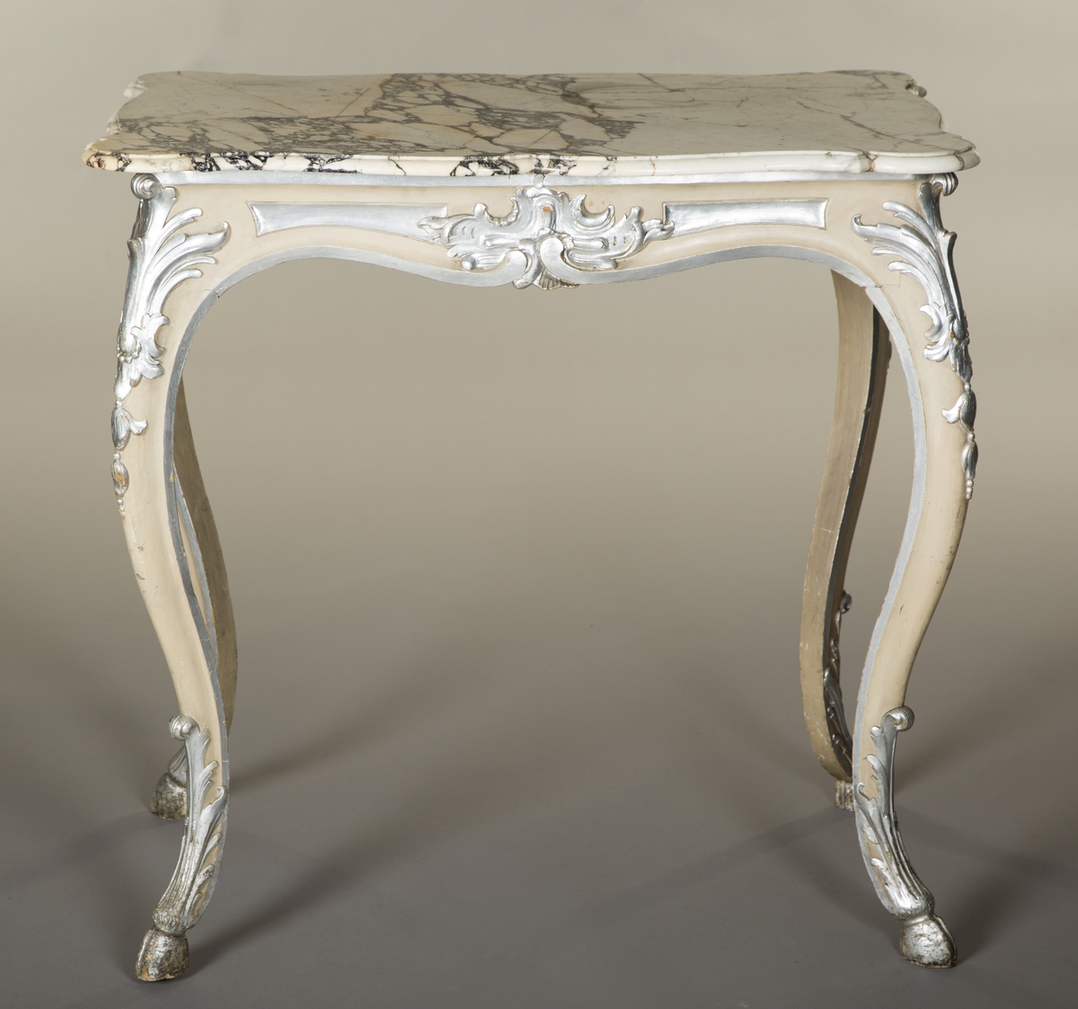 Rektangulært bord med treunderstell og marmorplate i nyrokokko. Malt lysegrått med forsølvete ornamenter. Sort og hvit marmorplate med svunget kontur. Cabrioleben med kloveavslutning. Sargens midtfelter har på kortsidene utskåret rocaille, og på langsidene skåret rankeverk. Bena har også skåret rankeverk.