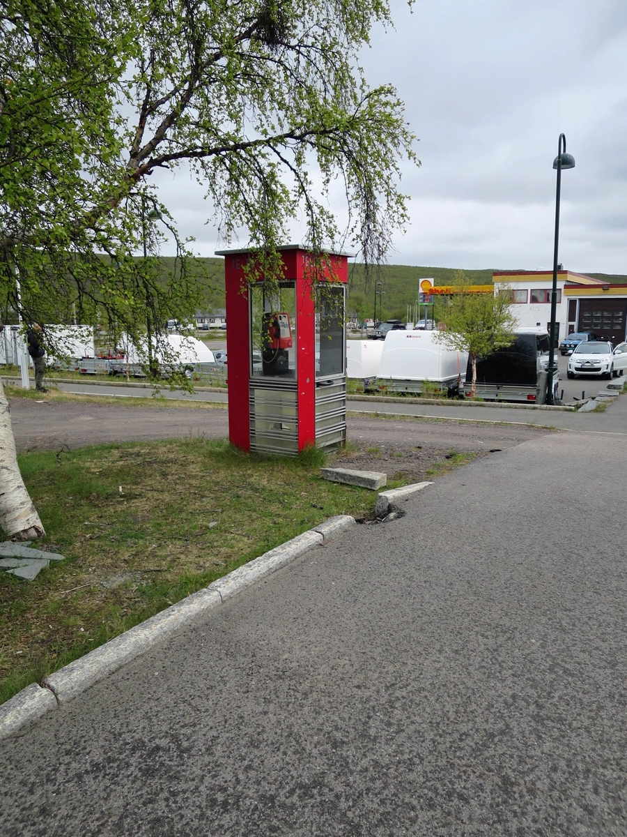 This is the story of how Norway’s most important conversation-space was designed by a young, freshly graduated man from Bergen.

“Norwegian architects are hereby invited…”
In the autumn of 1932, Oslo Telefonanlegginitiated an architectural competition. Finally, Oslo would get its own telephone booth. The city had had so called “talking-stations” from 1885, which in turn were overtaken by automatic telephones 
 only available at selected Narvesen kiosks. The state 
was of the opinion that now was the time to offer the public a better service; public telephone booths open 24/7, like the ones they already had in Sweden and England. But what would they look like, these new telephone booths? What considerations would it
 be necessary to take when designing it? The telegraph board developed a detailed list of demands and restraints: “The booth is intended to be placed outside on the streets and squares and need to be designed so that snow and ice does not hinder the opening and closing of the doors,” they wrote. “To prevent vandalism, theft, uncleanliness etc. inside the booth, it needs to be designed so that from all angles one may see what is going on in there.” Additionally, it would need to withstand storms and bad weather, and “preferably also being whipped by rain mixed with seawater” 

This was not all: The appearance would have to be «pleasing». The booth also needed to be movable, so that it could be taken in to be serviced at Telegrafverket’s main workshops. The reqired material was iron, and the surface was to be spray painted  preferably using car-body paint. There was a requirement for “a writing shelf, a pack shelf, and a suitable place for the telephone catalogue.” Also, there would need to be an illuminated TELEFON  sign, easily visible from all four angles. The total cost for each booth should not exceed 1000 kroner. The first prize for coming up with such a product was 800 kroner.

“Norwegianarchitects are hereby invited to partake in a competition for the design of a telephone booth…”  

The man with the solution
«At some point in 1932, Georg Fredrik sat at a party in Bergen. Maybe he felt a bit lost and forgotten as he often had throughout his life. He retreated to a quiet corner, took out a pencil and strted doodling on a matchbox.  According to my mother, this was how the telephone booth came into being.” In the book “Norges lille røde  historien om telefonkiosken,” Lars Fasting describes his father, the man who is far less known than the iconic architctural structure he left behind. Georg Fredrik Fasting was from Bergen, born into a family of working people and smallholders. One unusual facet of Georg Fredrik was that he was born without ears. His mother made sure he learnt to speak, read and write, 
ut Lars Fasting indicates that his father would seek refuge in drawing when the social challenges became too much to bear. And in the end drawing became his profession. In 1924 he secured a guarantor for a student loan, and started studying to become an a
rchitect at the NTH. Throughout the 1930s he entered several architectural competitions, with drafts produced, according to his son, “after work and in the late hours of the night.”

His efforts were not wasted. Out of 93 entries, with names such as “Flirt”, “Brrr”, “Ring” and “Amor”, the jury selected Fasting’s submission, “RIKS” as the new telephone booth: “The draft shows a strikingly simple solution to the task, technically as well as aesthetically well worked out.”

Taut and provident
Simple and aesthetc are the keywords here. Fasting had designed a booth pointing towards the future, and to modernism. Just how modern it was can be seen by comparing RIKS to the British telephone booth, also designed in the interwar-era. While the British version with it classicistic style is looking back to the heyday of the empire, Fasting’s booth is progressive and functionalistic. Like most Norwegian architects, Fasting broke with the classicistic style of architecture after the Stockholm-exhibition in 1930. “After it, almost all buildings erected in Norway until the German invasion in 1940, were in the functionalistic architectural style,” writes senior curator of architecture at the Norwegian National Museum, Ulf Grønvold, in the book, “Den lille røde”.“TheNorwegian booth is a piece of functionalistic architecture, an asymmetric composition with its roof slab overhanging the word TELEFON, in bold sans seraph lettering,”concludes Ulf Grønvold.

Fashionably red
And it was red. Fasting chose a colour which was part of the modern palette. “A bright red colour, but not as shiny as a signal red, the character of the colour places it among the fashionable colours within functionalism,” states paintings conservator and researcher in NIKU (Norwegian Institute for Cultural Heitage Research), Jon Brænne. In his opinion, Fasting went for visibility without making the booth stand out too much from its surroundings. The original colour was in use up to around 1950, when it changed to signal red. Towards the end of the 1970s the clour was again adjusted towards today’s orangey red.

The design, however, has not changed. RIKS is eighty years and still looks remarkably good. That’s what makes Fasting’s telephone booth a classic  even before it was added to DOCOMOMO’s list over moden icons of design. For Telenor, the telephone booth has served as a pathway into the hearts of the public. For many, Telenor (Televerket) was synonymous with exactly this telephone booth, because this was where one would go to place a call. Having a home
phone was not common until the 1980s. As such the red box became part of the Norwegian everyday and consciousness. The symbol- and publicity value of this is hard to evaluate, but in 2007 it was time to give honour where honour was due, Telenor, in consul
tation with the Directorate for Cultural Heritage, decided to preserve 100 telephone booths for all eternity.

And what about Georg Fredrik Fasting? What happened to him? At the age of 56 an entry in his diary states: «I CAN HEAR». As the first person in th world he had undergone an operation where he had ear canals constructed and eardrums fitted. For the rest of his life, the man behind Norway’s own telephone booth could answer the telephone himself.

Source: Norges lille røde historien om telefonkiosken (2007), issued by The Norwegian Telecom Museum and Telenor Cultural Heritage.