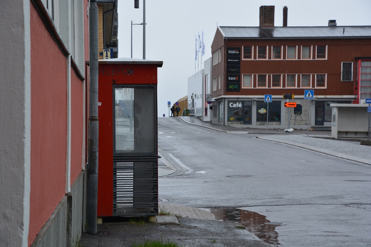 This is the story of how Norway’s most important conversation-space was designed by a young, freshly graduated man from Bergen.

“Norwegian architects are hereby invited…”
In the autumn of 1932, Oslo Telefonanlegginitiated an architectural competition. Finally, Oslo would get its own telephone booth. The city had had so called “talking-stations” from 1885, which in turn were overtaken by automatic telephones 
 only available at selected Narvesen kiosks. The state 
was of the opinion that now was the time to offer the public a better service; public telephone booths open 24/7, like the ones they already had in Sweden and England. But what would they look like, these new telephone booths? What considerations would it
 be necessary to take when designing it? The telegraph board developed a detailed list of demands and restraints: “The booth is intended to be placed outside on the streets and squares and need to be designed so that snow and ice does not hinder the opening and closing of the doors,” they wrote. “To prevent vandalism, theft, uncleanliness etc. inside the booth, it needs to be designed so that from all angles one may see what is going on in there.” Additionally, it would need to withstand storms and bad weather, and “preferably also being whipped by rain mixed with seawater” 

This was not all: The appearance would have to be «pleasing». The booth also needed to be movable, so that it could be taken in to be serviced at Telegrafverket’s main workshops. The reqired material was iron, and the surface was to be spray painted  preferably using car-body paint. There was a requirement for “a writing shelf, a pack shelf, and a suitable place for the telephone catalogue.” Also, there would need to be an illuminated TELEFON  sign, easily visible from all four angles. The total cost for each booth should not exceed 1000 kroner. The first prize for coming up with such a product was 800 kroner.

“Norwegianarchitects are hereby invited to partake in a competition for the design of a telephone booth…”  

The man with the solution
«At some point in 1932, Georg Fredrik sat at a party in Bergen. Maybe he felt a bit lost and forgotten as he often had throughout his life. He retreated to a quiet corner, took out a pencil and strted doodling on a matchbox.  According to my mother, this was how the telephone booth came into being.” In the book “Norges lille røde  historien om telefonkiosken,” Lars Fasting describes his father, the man who is far less known than the iconic architctural structure he left behind. Georg Fredrik Fasting was from Bergen, born into a family of working people and smallholders. One unusual facet of Georg Fredrik was that he was born without ears. His mother made sure he learnt to speak, read and write, 
ut Lars Fasting indicates that his father would seek refuge in drawing when the social challenges became too much to bear. And in the end drawing became his profession. In 1924 he secured a guarantor for a student loan, and started studying to become an a
rchitect at the NTH. Throughout the 1930s he entered several architectural competitions, with drafts produced, according to his son, “after work and in the late hours of the night.”

His efforts were not wasted. Out of 93 entries, with names such as “Flirt”, “Brrr”, “Ring” and “Amor”, the jury selected Fasting’s submission, “RIKS” as the new telephone booth: “The draft shows a strikingly simple solution to the task, technically as well as aesthetically well worked out.”

Taut and provident
Simple and aesthetc are the keywords here. Fasting had designed a booth pointing towards the future, and to modernism. Just how modern it was can be seen by comparing RIKS to the British telephone booth, also designed in the interwar-era. While the British version with it classicistic style is looking back to the heyday of the empire, Fasting’s booth is progressive and functionalistic. Like most Norwegian architects, Fasting broke with the classicistic style of architecture after the Stockholm-exhibition in 1930. “After it, almost all buildings erected in Norway until the German invasion in 1940, were in the functionalistic architectural style,” writes senior curator of architecture at the Norwegian National Museum, Ulf Grønvold, in the book, “Den lille røde”.“TheNorwegian booth is a piece of functionalistic architecture, an asymmetric composition with its roof slab overhanging the word TELEFON, in bold sans seraph lettering,”concludes Ulf Grønvold.

Fashionably red
And it was red. Fasting chose a colour which was part of the modern palette. “A bright red colour, but not as shiny as a signal red, the character of the colour places it among the fashionable colours within functionalism,” states paintings conservator and researcher in NIKU (Norwegian Institute for Cultural Heitage Research), Jon Brænne. In his opinion, Fasting went for visibility without making the booth stand out too much from its surroundings. The original colour was in use up to around 1950, when it changed to signal red. Towards the end of the 1970s the clour was again adjusted towards today’s orangey red.

The design, however, has not changed. RIKS is eighty years and still looks remarkably good. That’s what makes Fasting’s telephone booth a classic  even before it was added to DOCOMOMO’s list over moden icons of design. For Telenor, the telephone booth has served as a pathway into the hearts of the public. For many, Telenor (Televerket) was synonymous with exactly this telephone booth, because this was where one would go to place a call. Having a home
phone was not common until the 1980s. As such the red box became part of the Norwegian everyday and consciousness. The symbol- and publicity value of this is hard to evaluate, but in 2007 it was time to give honour where honour was due, Telenor, in consul
tation with the Directorate for Cultural Heritage, decided to preserve 100 telephone booths for all eternity.

And what about Georg Fredrik Fasting? What happened to him? At the age of 56 an entry in his diary states: «I CAN HEAR». As the first person in th world he had undergone an operation where he had ear canals constructed and eardrums fitted. For the rest of his life, the man behind Norway’s own telephone booth could answer the telephone himself.

Source: Norges lille røde historien om telefonkiosken (2007), issued by The Norwegian Telecom Museum and Telenor Cultural Heritage.