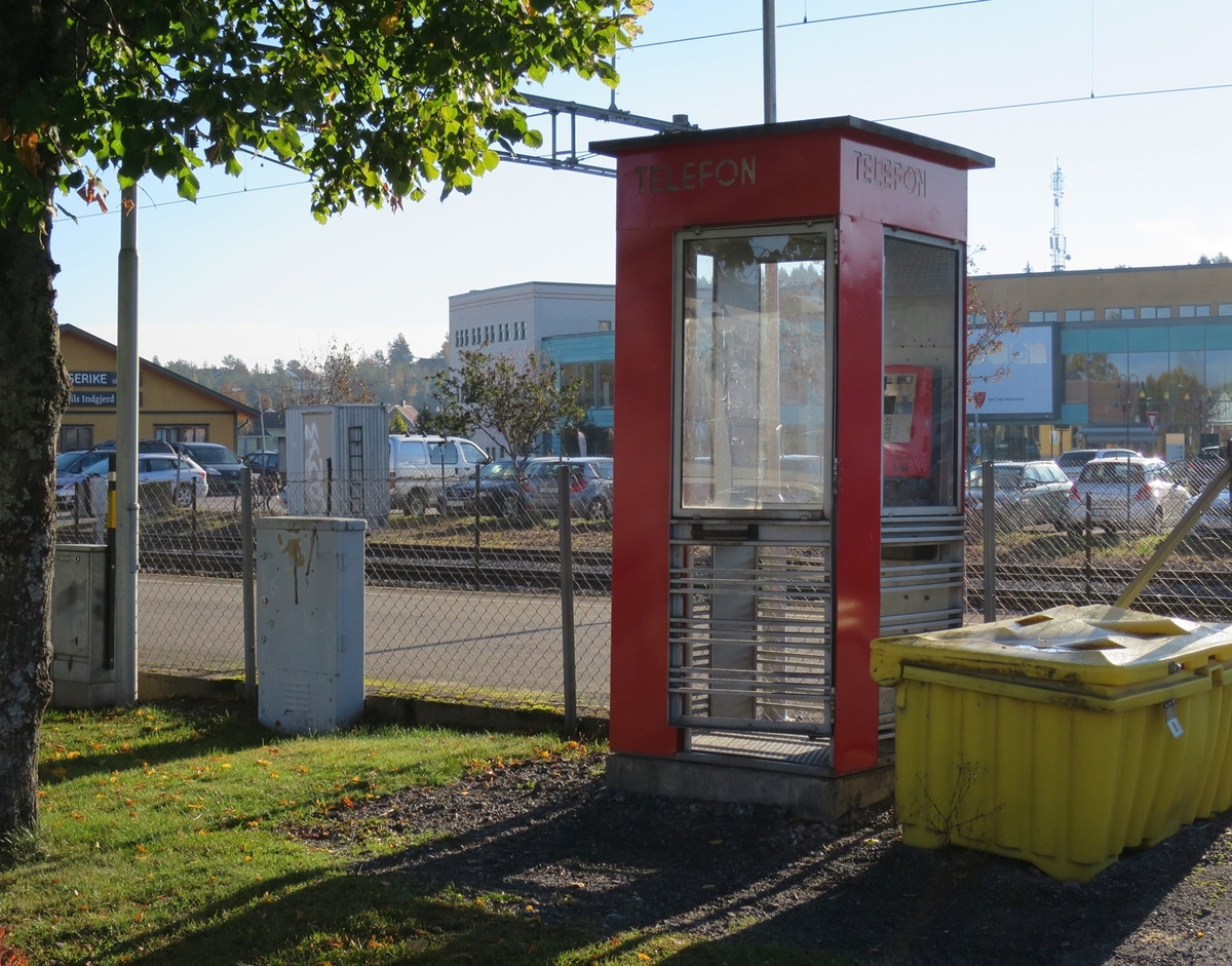 This is the story of how Norway’s most important conversation-space was designed by a young, freshly graduated man from Bergen.

“Norwegian architects are hereby invited…”
In the autumn of 1932, Oslo Telefonanlegginitiated an architectural competition. Finally, Oslo would get its own telephone booth. The city had had so called “talking-stations” from 1885, which in turn were overtaken by automatic telephones 
 only available at selected Narvesen kiosks. The state 
was of the opinion that now was the time to offer the public a better service; public telephone booths open 24/7, like the ones they already had in Sweden and England. But what would they look like, these new telephone booths? What considerations would it
 be necessary to take when designing it? The telegraph board developed a detailed list of demands and restraints: “The booth is intended to be placed outside on the streets and squares and need to be designed so that snow and ice does not hinder the opening and closing of the doors,” they wrote. “To prevent vandalism, theft, uncleanliness etc. inside the booth, it needs to be designed so that from all angles one may see what is going on in there.” Additionally, it would need to withstand storms and bad weather, and “preferably also being whipped by rain mixed with seawater” 

This was not all: The appearance would have to be «pleasing». The booth also needed to be movable, so that it could be taken in to be serviced at Telegrafverket’s main workshops. The reqired material was iron, and the surface was to be spray painted  preferably using car-body paint. There was a requirement for “a writing shelf, a pack shelf, and a suitable place for the telephone catalogue.” Also, there would need to be an illuminated TELEFON  sign, easily visible from all four angles. The total cost for each booth should not exceed 1000 kroner. The first prize for coming up with such a product was 800 kroner.

“Norwegianarchitects are hereby invited to partake in a competition for the design of a telephone booth…”  

The man with the solution
«At some point in 1932, Georg Fredrik sat at a party in Bergen. Maybe he felt a bit lost and forgotten as he often had throughout his life. He retreated to a quiet corner, took out a pencil and strted doodling on a matchbox.  According to my mother, this was how the telephone booth came into being.” In the book “Norges lille røde  historien om telefonkiosken,” Lars Fasting describes his father, the man who is far less known than the iconic architctural structure he left behind. Georg Fredrik Fasting was from Bergen, born into a family of working people and smallholders. One unusual facet of Georg Fredrik was that he was born without ears. His mother made sure he learnt to speak, read and write, 
ut Lars Fasting indicates that his father would seek refuge in drawing when the social challenges became too much to bear. And in the end drawing became his profession. In 1924 he secured a guarantor for a student loan, and started studying to become an a
rchitect at the NTH. Throughout the 1930s he entered several architectural competitions, with drafts produced, according to his son, “after work and in the late hours of the night.”

His efforts were not wasted. Out of 93 entries, with names such as “Flirt”, “Brrr”, “Ring” and “Amor”, the jury selected Fasting’s submission, “RIKS” as the new telephone booth: “The draft shows a strikingly simple solution to the task, technically as well as aesthetically well worked out.”

Taut and provident
Simple and aesthetc are the keywords here. Fasting had designed a booth pointing towards the future, and to modernism. Just how modern it was can be seen by comparing RIKS to the British telephone booth, also designed in the interwar-era. While the British version with it classicistic style is looking back to the heyday of the empire, Fasting’s booth is progressive and functionalistic. Like most Norwegian architects, Fasting broke with the classicistic style of architecture after the Stockholm-exhibition in 1930. “After it, almost all buildings erected in Norway until the German invasion in 1940, were in the functionalistic architectural style,” writes senior curator of architecture at the Norwegian National Museum, Ulf Grønvold, in the book, “Den lille røde”.“TheNorwegian booth is a piece of functionalistic architecture, an asymmetric composition with its roof slab overhanging the word TELEFON, in bold sans seraph lettering,”concludes Ulf Grønvold.

Fashionably red
And it was red. Fasting chose a colour which was part of the modern palette. “A bright red colour, but not as shiny as a signal red, the character of the colour places it among the fashionable colours within functionalism,” states paintings conservator and researcher in NIKU (Norwegian Institute for Cultural Heitage Research), Jon Brænne. In his opinion, Fasting went for visibility without making the booth stand out too much from its surroundings. The original colour was in use up to around 1950, when it changed to signal red. Towards the end of the 1970s the clour was again adjusted towards today’s orangey red.

The design, however, has not changed. RIKS is eighty years and still looks remarkably good. That’s what makes Fasting’s telephone booth a classic  even before it was added to DOCOMOMO’s list over moden icons of design. For Telenor, the telephone booth has served as a pathway into the hearts of the public. For many, Telenor (Televerket) was synonymous with exactly this telephone booth, because this was where one would go to place a call. Having a home
phone was not common until the 1980s. As such the red box became part of the Norwegian everyday and consciousness. The symbol- and publicity value of this is hard to evaluate, but in 2007 it was time to give honour where honour was due, Telenor, in consul
tation with the Directorate for Cultural Heritage, decided to preserve 100 telephone booths for all eternity.

And what about Georg Fredrik Fasting? What happened to him? At the age of 56 an entry in his diary states: «I CAN HEAR». As the first person in th world he had undergone an operation where he had ear canals constructed and eardrums fitted. For the rest of his life, the man behind Norway’s own telephone booth could answer the telephone himself.

Source: Norges lille røde historien om telefonkiosken (2007), issued by The Norwegian Telecom Museum and Telenor Cultural Heritage.