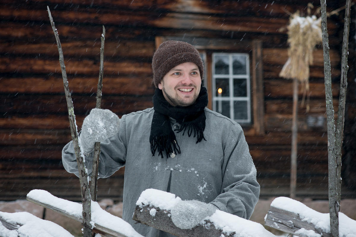 Mann står ved en skigard med snø på.