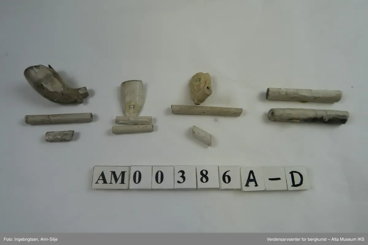 En samling fragmenter av krittpiper. Et av pipehodene er mer eller mindre hel, men med avbrukket pipehals. 

Fragmentene varierer i størrelse fra 1,5 cm til 5,7 cm i lengde og 0,5 cm til 2 cm i bredde.