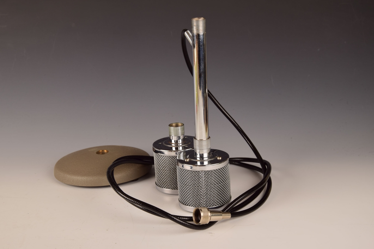 Mikrofon med ledning, stativ og ekstra mikrofonhode i eske med lokk.