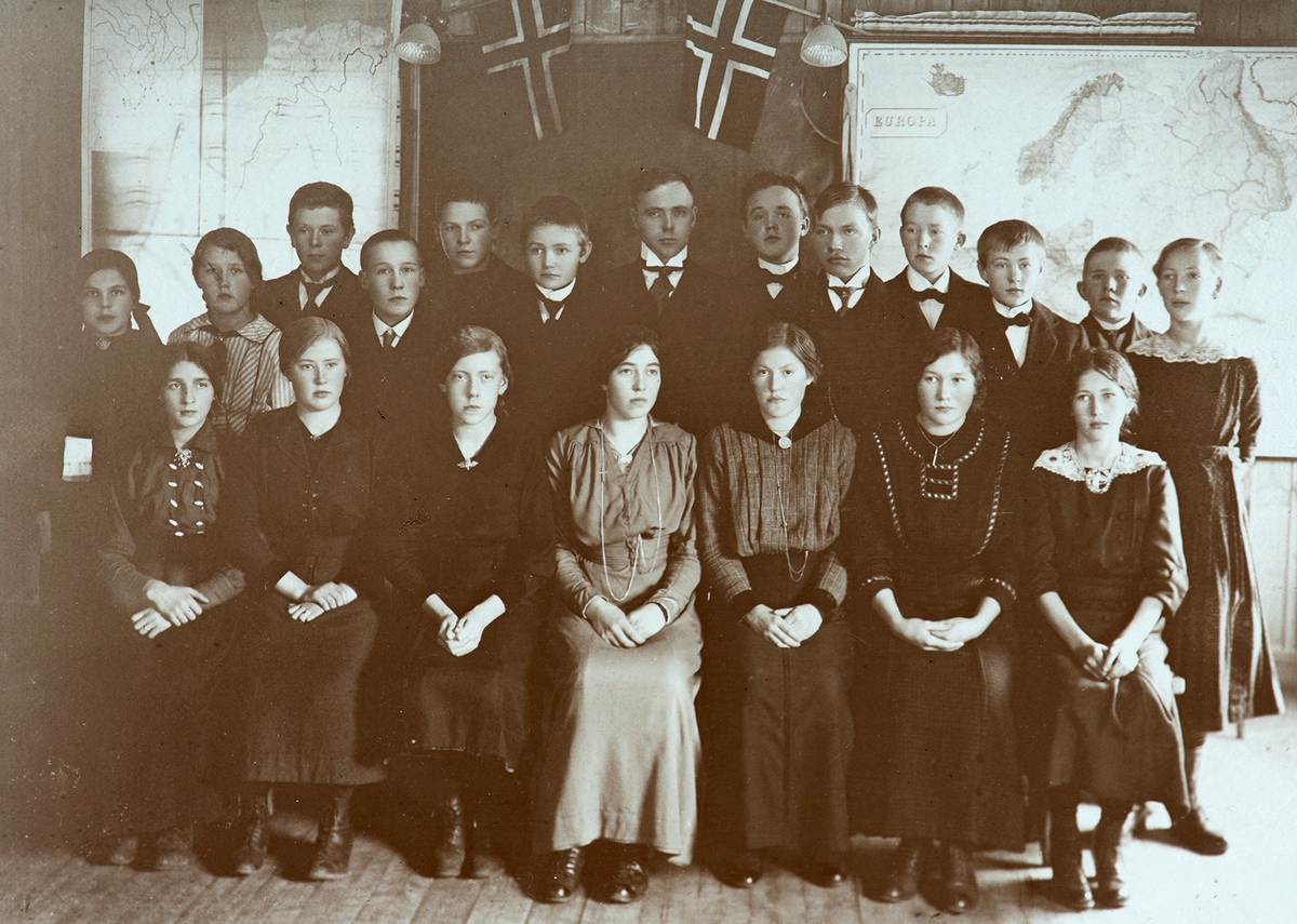 Tomter skole, Vallset, gruppe elever og lærere i klasserom. Norske flagg, kart. Ukjente.