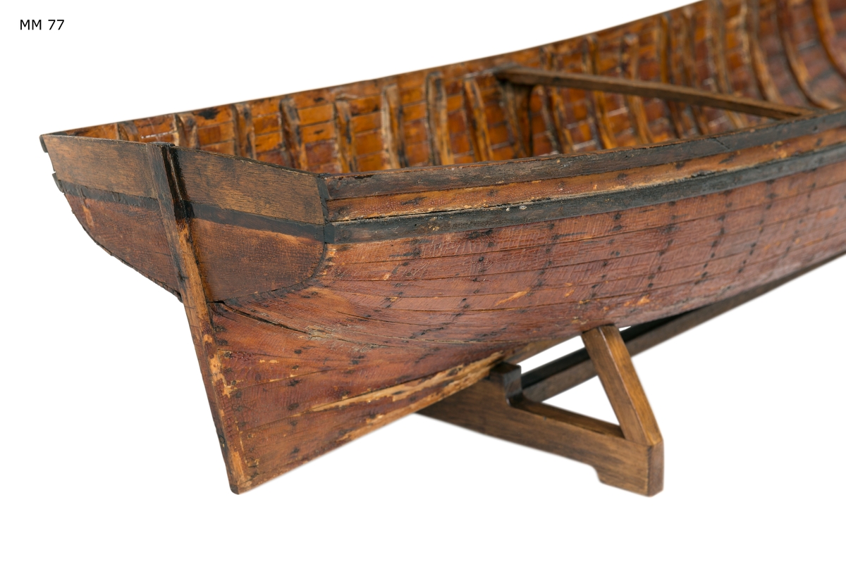 Skrovmodell av fartyg, bordlagd i kravell på bottenstockar och spant, med akterstäv och akterspegel men utan uppbyggd galjon.
Översta bordgången och berghultet svartmålade, övrigt fernissad med nu krackelerad linoljefernissa.