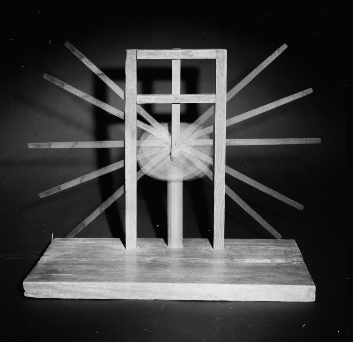 Modell ur Polhems mekaniska alfabet. Text på föremålet: "LXIV". Vid rotation av den lodräta axeln erhålles med hjälp av den vinkelställda skivan en vickande rörelse hos armen.