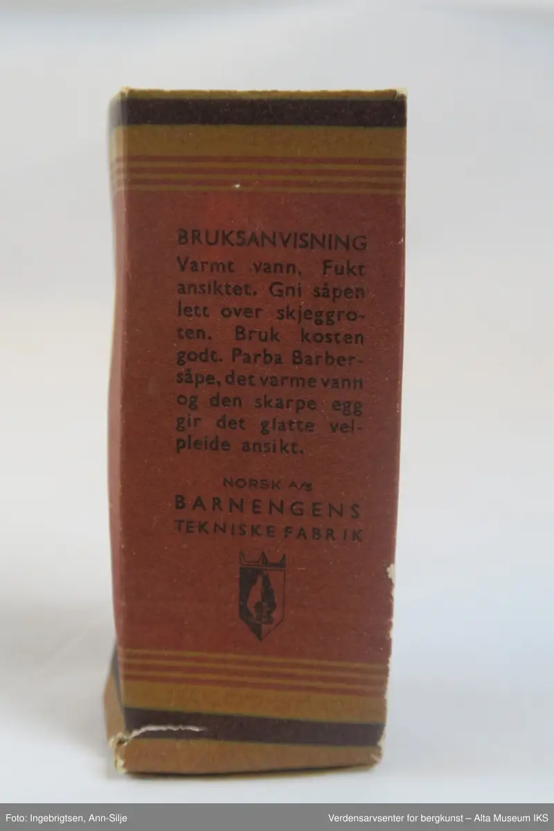 Rektangulær eske med en sylinderformet såpe på innsiden.