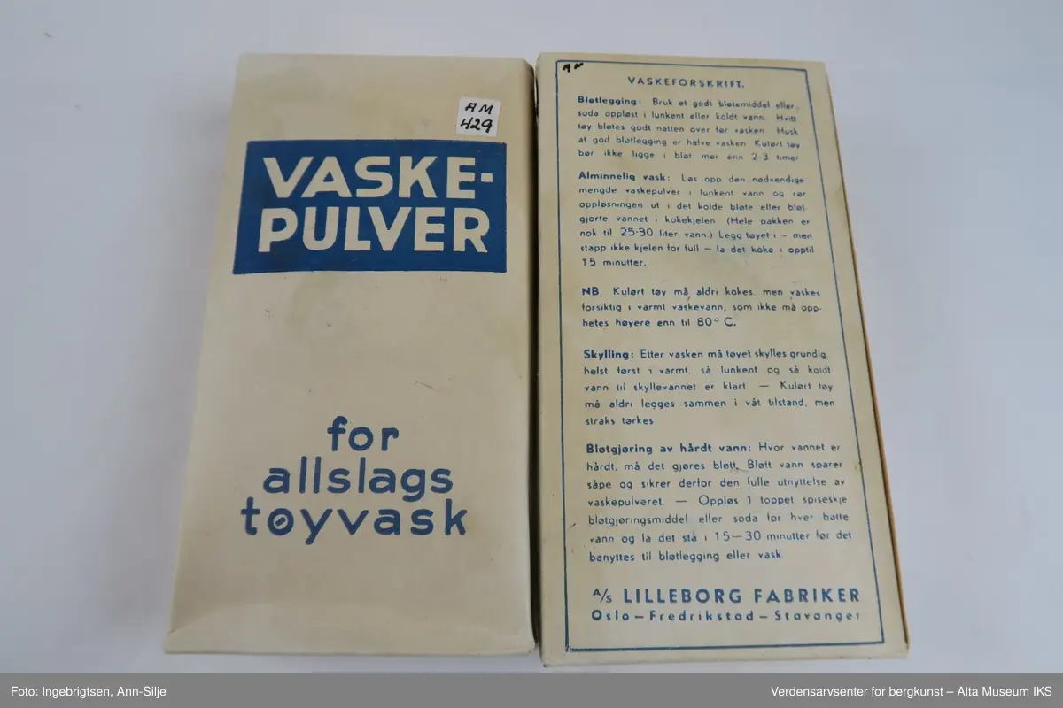Hvit rektangulær pakke med pulver. Øverst på pakkens forside er det et blått felt med hvit skrift. Ellers er det tekst i blått skrevet på alle sidene på pakken.