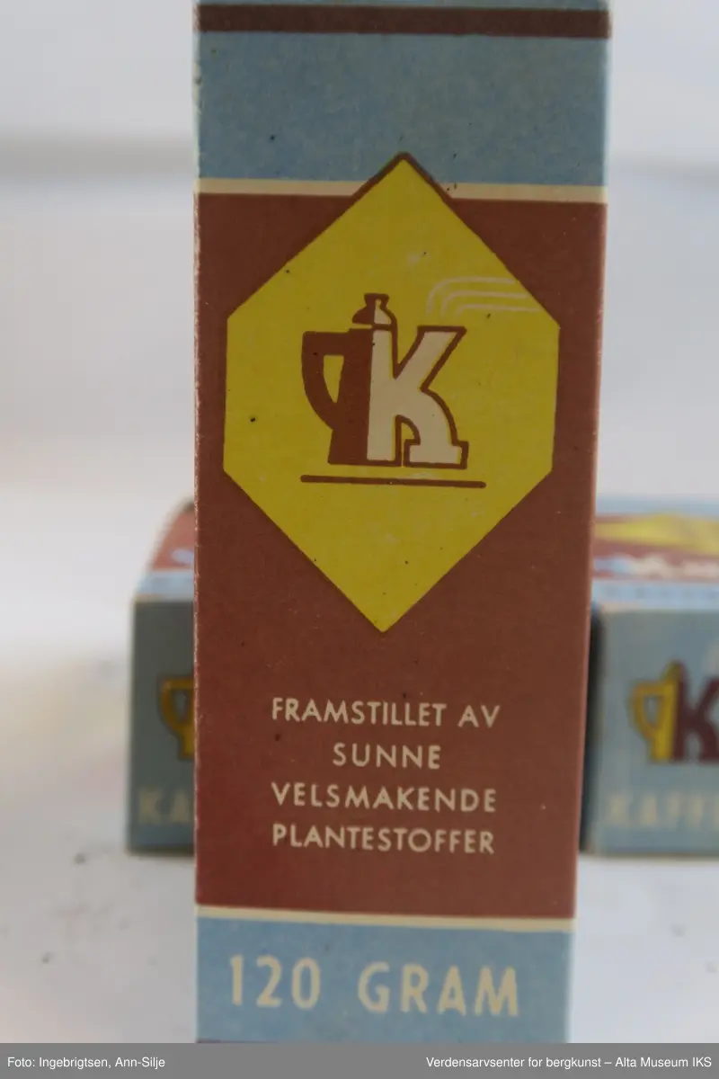 Rektangulære esker som innholder pulver. På eskenes forside er det en logo. Logoen er formet som en ruter, og inn i  ruten er det en "R" med en prikk over. Under logoen er det tekst.
