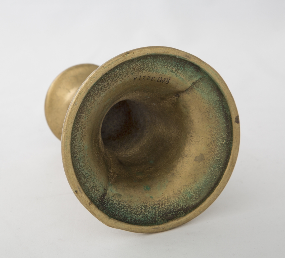 Rund sokkel, slank utføring. Dekorert med to riller på sokkel, og to riller på skaftet. Vider seg ut ved lyspipen.