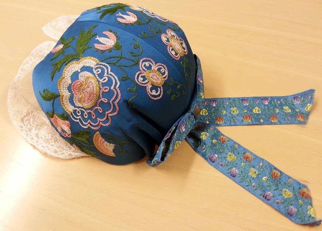 Hembygdsdräkt från Breared,Halland.
SKJORTA i Linneväv Handsydd med lingarn och med broderad smock på handled och överarm med röd och vit bomullsgarn. broderi på krage och knäppslå.
LIVSTYCKE: Handsytt Yttertyg Handvävt i rosa och blå opphämtaränder på blekt tuskaftsbotten. Blekt linnefoder.
KJOL: Handsytt i blå tuskaftsylle, 3 meter i omkrets med smockveck i midjan från - höftkam - bak - höftkam.
Linning knäppe fram.
FÖRKLÄDE: Handsytt av Handnävt i rosengång med rosa, blått och vitt bomullsgarn.
SJAL: 1/2 Fyrkant delad på tvären.Handvävd i tuskaft med blått Bomullsgarn .
Broderad mit bak med silketråd i rosa,grön mm.
HÄTTA: broderad med silkegarn på blått sidentyg och monterad på mjuk stomme.
KJOLVÄSKA: Handsydd av röd ylleväv,fodrad med oblekt linneväv, blå -grönt band runt ytterkant och monterad med silverbygel, broderad med blå,gul,vit ullgarn,