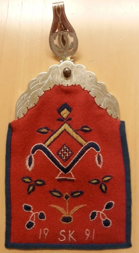 Hembygdsdräkt från Breared,Halland.
SKJORTA i Linneväv Handsydd med lingarn och med broderad smock på handled och överarm med röd och vit bomullsgarn. broderi på krage och knäppslå.
LIVSTYCKE: Handsytt Yttertyg Handvävt i rosa och blå opphämtaränder på blekt tuskaftsbotten. Blekt linnefoder.
KJOL: Handsytt i blå tuskaftsylle, 3 meter i omkrets med smockveck i midjan från - höftkam - bak - höftkam.
Linning knäppe fram.
FÖRKLÄDE: Handsytt av Handnävt i rosengång med rosa, blått och vitt bomullsgarn.
SJAL: 1/2 Fyrkant delad på tvären.Handvävd i tuskaft med blått Bomullsgarn .
Broderad mit bak med silketråd i rosa,grön mm.
HÄTTA: broderad med silkegarn på blått sidentyg och monterad på mjuk stomme.
KJOLVÄSKA: Handsydd av röd ylleväv,fodrad med oblekt linneväv, blå -grönt band runt ytterkant och monterad med silverbygel, broderad med blå,gul,vit ullgarn,