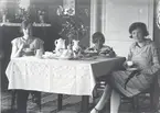 Kring kaffebordet. Från vänster: Ebba Johansson gift med lantbrukaren John Johansson, Riskebo, dottern Greta och längst till höger Ebbas syster Gerda, gift Fransson.