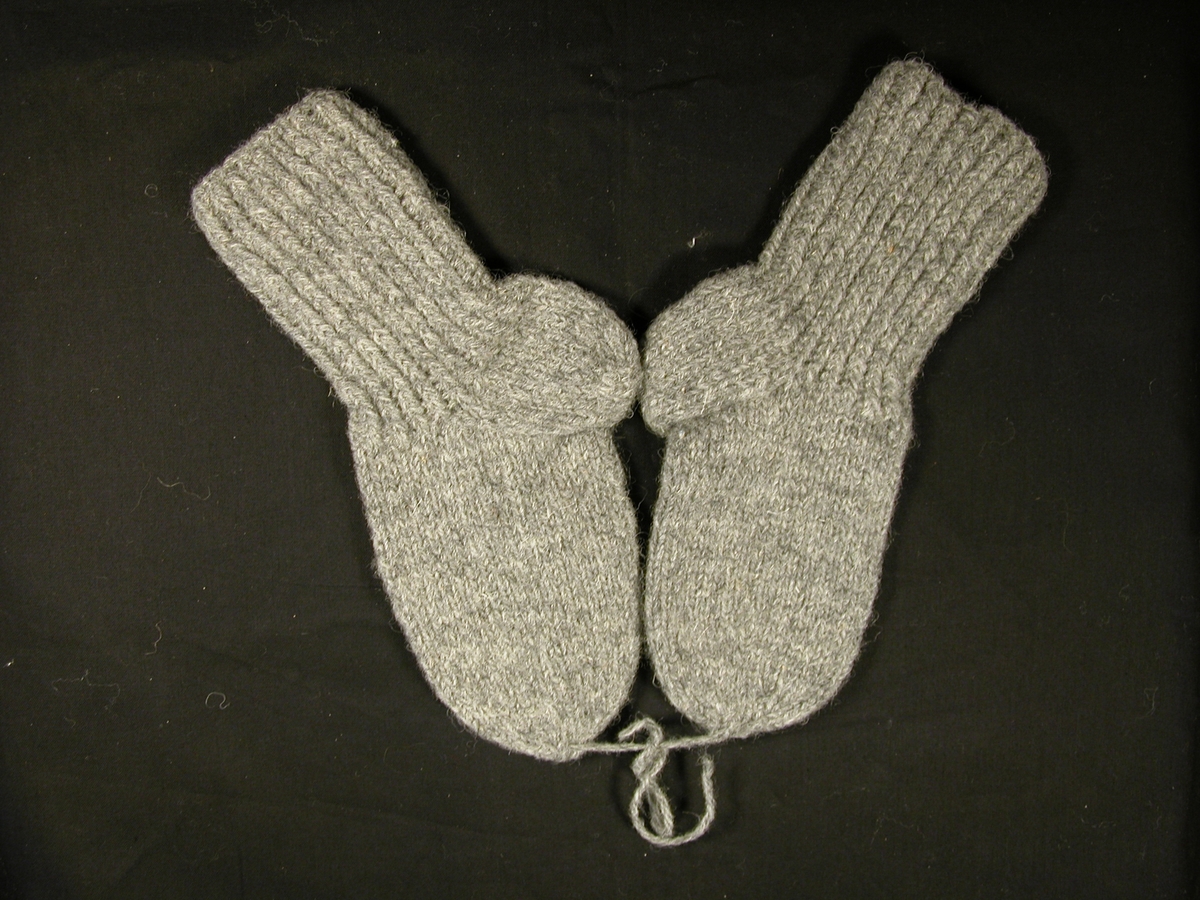 Et par ullstrøpmer til barn i grått ullgarn. Fremstår som ubrukt.