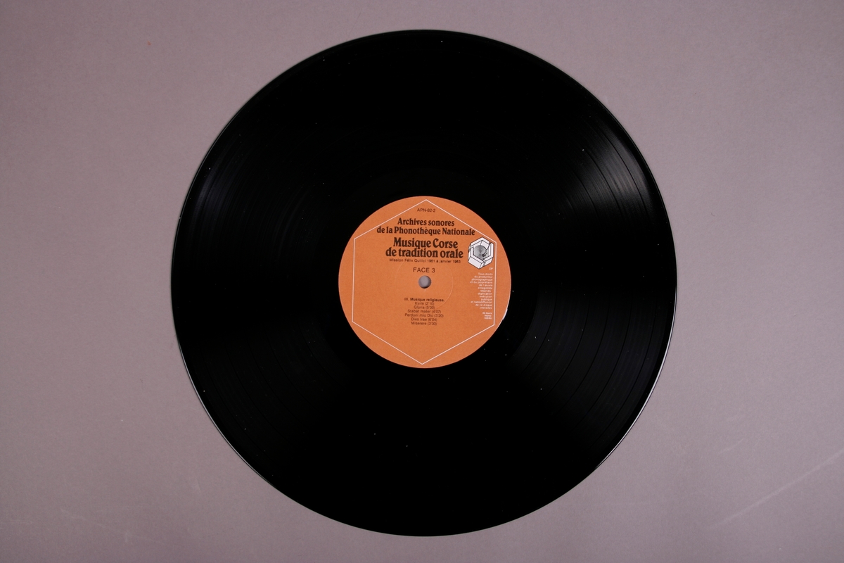 Plateomslag i form av en eske i oransje stoff, tre grammofonplater i svart vinyl som ligger i papirlommer, samt et hefte. I tillegg et klistremerke inne i  esken.