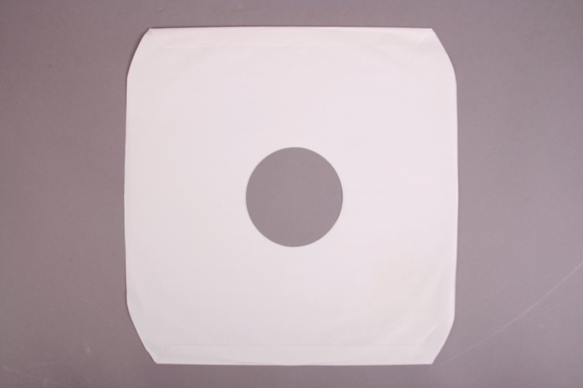 Plateomslag i form av en eske i oransje stoff, tre grammofonplater i svart vinyl som ligger i papirlommer, samt et hefte. I tillegg et klistremerke inne i  esken.