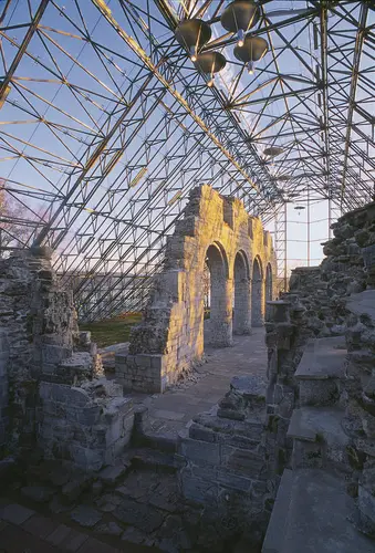 Morgensola lyser opp søylerekka av domkirkeruinen under vernebygget i glass og stål.