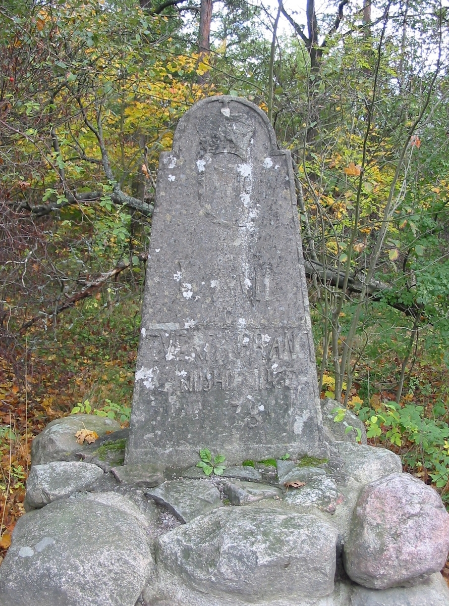 Helmilstolpe i sten från 1781 med krona och kungamonogram G III (Gustav III) samt landshövdingenamn längst ner "Evert A Franc".