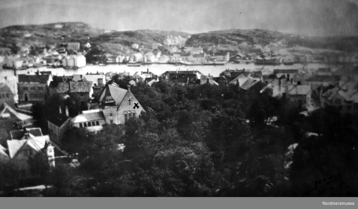 Det "nye" bedehuset i førkrigs-Kristiansund er merka med x. Fotografen har stått på Parkhaugen/Moses' plass. Fengselet er dekka av trær. I bakgrunnen ses Innlandet. Nordmøre Museums fotosamling