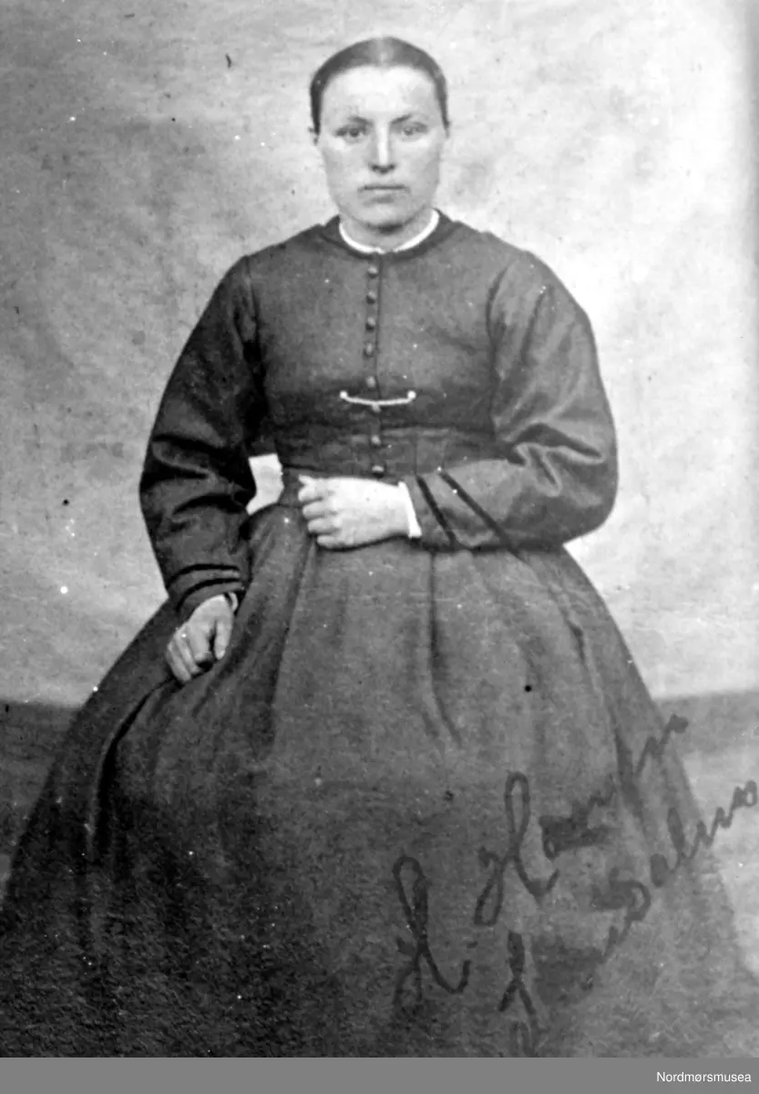 Dette portrettet må være tatt på slutten av 1860-tallet. Det ser vi på klesdrakten, hårfrisyren og bakgrunnen. Kan ha vært tatt av en omreisende fotograf, og ganske sikkert ikke i et atelier. (info: Astrid Kvendbø). - 

Et eldre portrett foto av ei dame i allmuekjole. Bildet er fra Surnadal,  Bildet har påført tekst, trolig "H.Hansen " Fra Nordmøre Museums fotosamlinger.