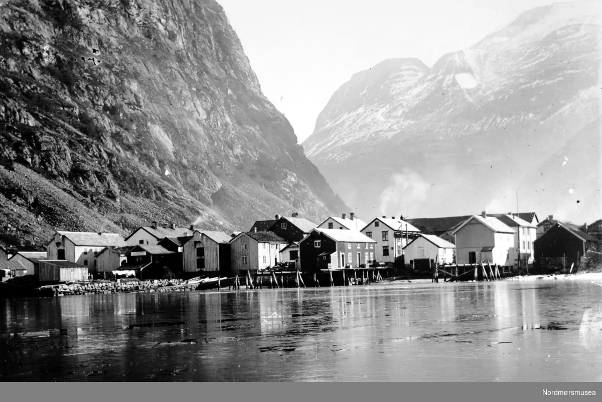 Et vinterbilde fra sjøsiden i Sunndal kommune, hvor vi per 1983 finner Aluminumsverket. Her ser vi diverse sjøboder, brygger og våninghus. Bildet er datert til før 1940. Se også KMb-1943-000.0551 samt KMb-2007-007.0047. Fra Nordmøre Museums fotosamlinger.
