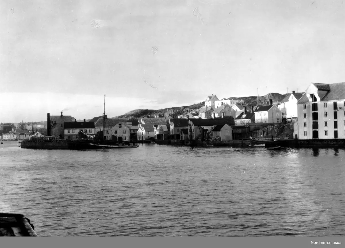 Foto tatt fra Nordlandet og vi ser over Nordsundet til Nordholmen til høyre midt i bildet og bebyggelsen på Gomalandet.  Til høyre i bildet ser vi et hvitt hus med flatt tak, Hunnes-eiendommen.  Størstedelen av denne bebyggelsen vi her ser brant ned i aprildagene 1940.  Ett av husene som ble berget var Hunnes-eiendommen.  Brannbomber falt ned på det flate taket, men beboerne var oppmerksomme og fikk fjernet disse og boligen ble reddet. Nordmøre museums fotosamling