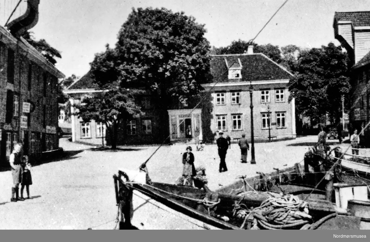 Jubileumsmappe 1742 - 1942 utgitt av Monge Foto, Kristiansund i 1942.
I Johnsenhuken i Vågen med øyværingenes gamle båter i begynnelsen av 1900-årene.
Nordmøre Museum si fotosamling