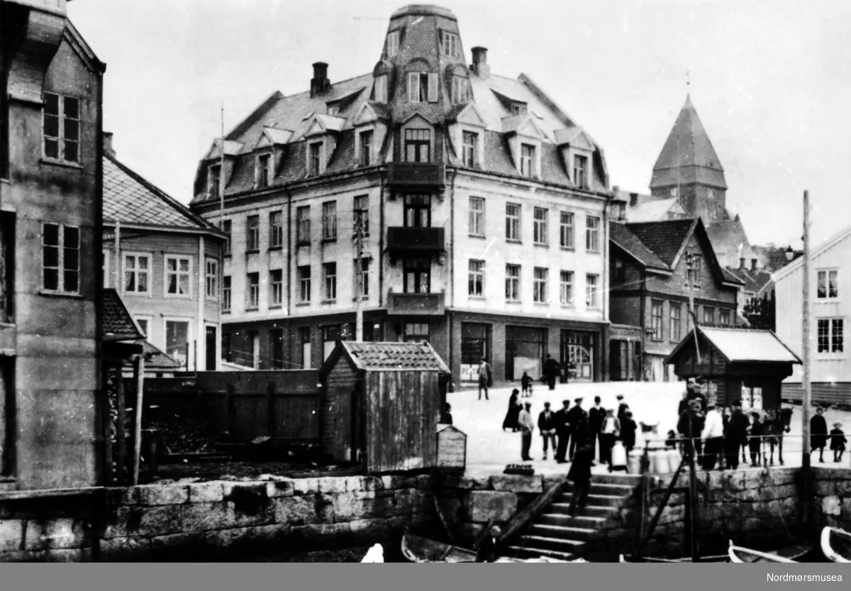 Jubileumsmappe 1742 - 1942 utgitt av Monge Foto, Kristiansund i 1942.
Fra Nordlandets almenning; Grunden.  Fra venstre brygge, Flyumgården, Iversengården fra 1914, kirken bygget 1914, Halsgården.
(Frå Nordmøre Museum si fotosamling)