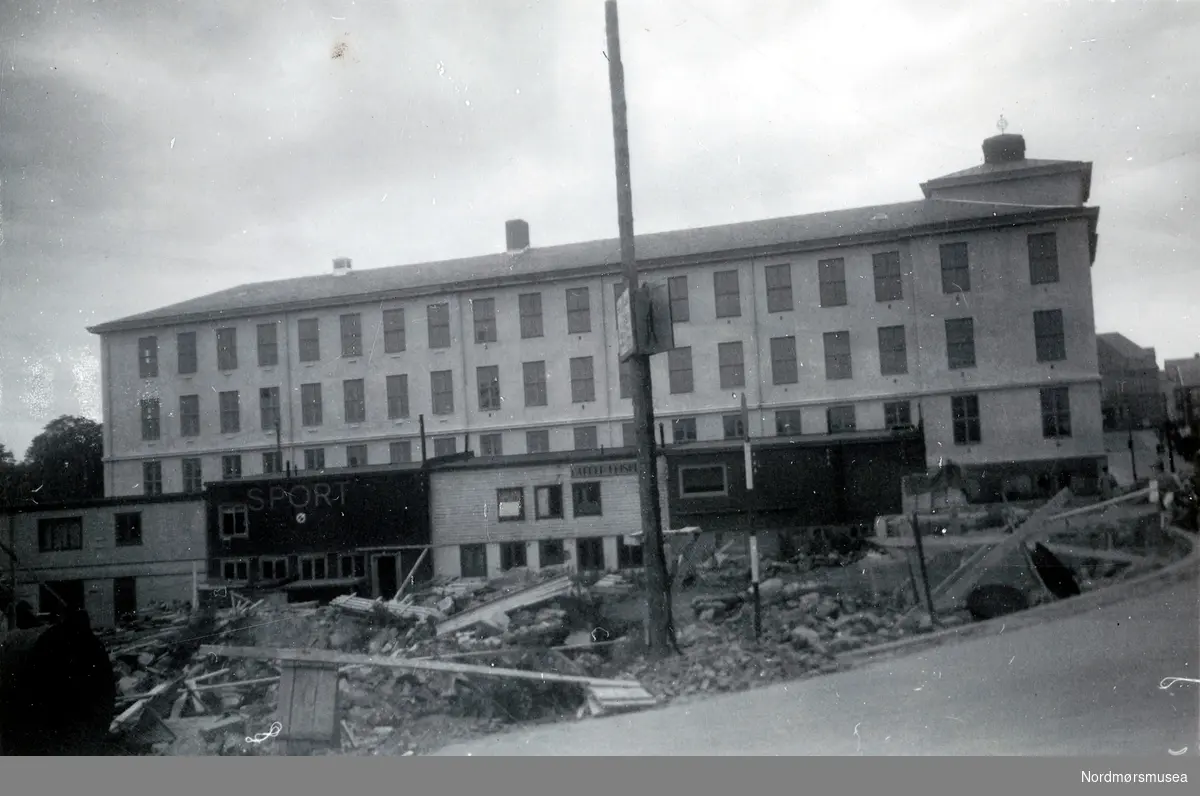 Tidligere Den Høgre skole og Langveien ungdomskole ved Skolegata og Langveien lenger i bakgrunnen, samt med brakkebebyggelsen på skoleplana i front. Bildet er trolig fra gjenreisningen av Kristiansund etter bombingen av byen i aprildagene 1940. Fra Nordmøre museums fotosamlinger.
