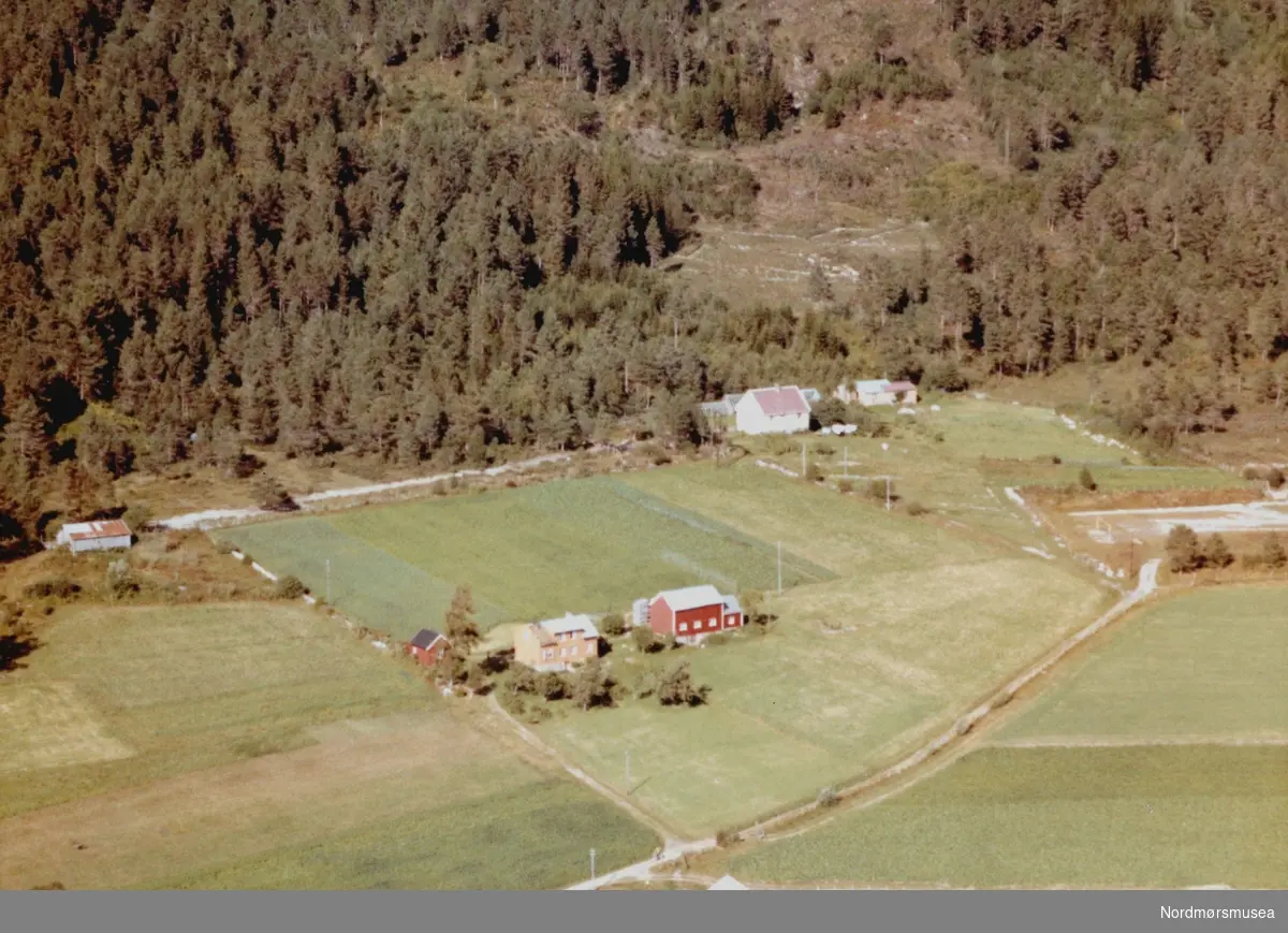 Flyfoto fra blant annet gården ";Kveldheim"; tilhørende Jon Guttormsen på Gyl i Tingvoll kommune. Bildet er datert 30. juli 1963, og fotograf er Widerøe's Flyveselskap a/s. Fra Nordmøre Museums fotosamlinger.
