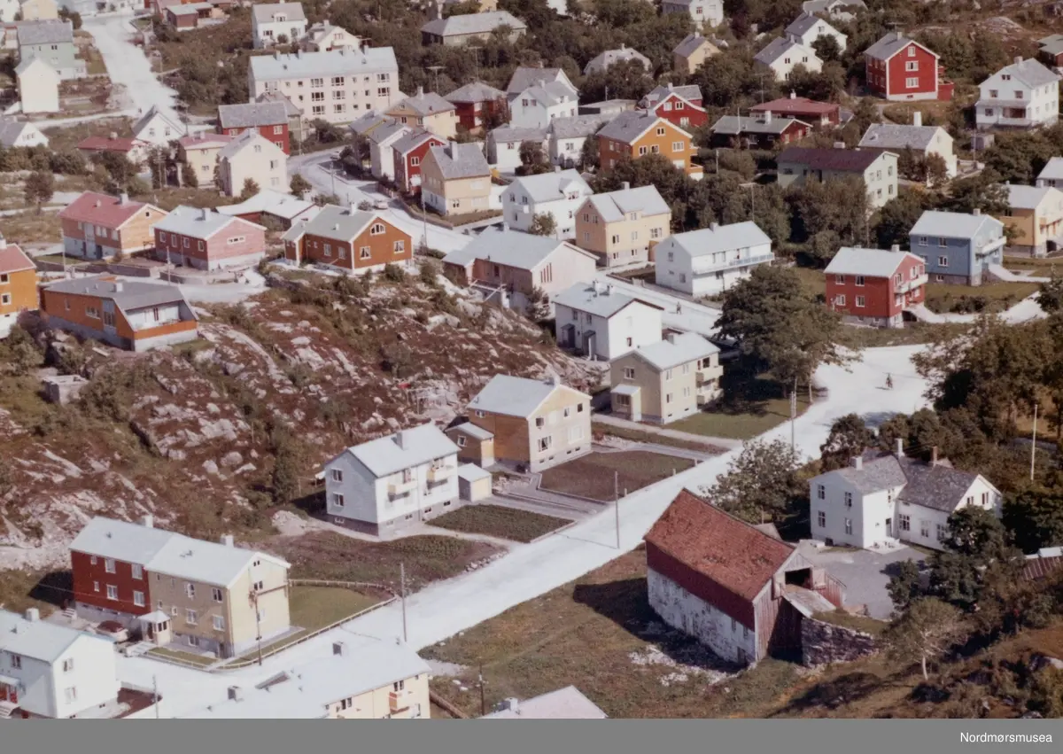 Flyfoto over Kirkelandet i Kristiansund, datert 11. juli 1962. Krysset Brinchmanns vei/Kaasbøls vei. Midt på bildet Sangens Hus, huser i dag 2008 Midtnorsk Ballettsenter (Operaen i Kristiansund).  Myra gård, eid av fam Kvalvåg. Her lå "Kvitporten": bygrensa. (Fra Nordmøre Museums fotosamlinger)